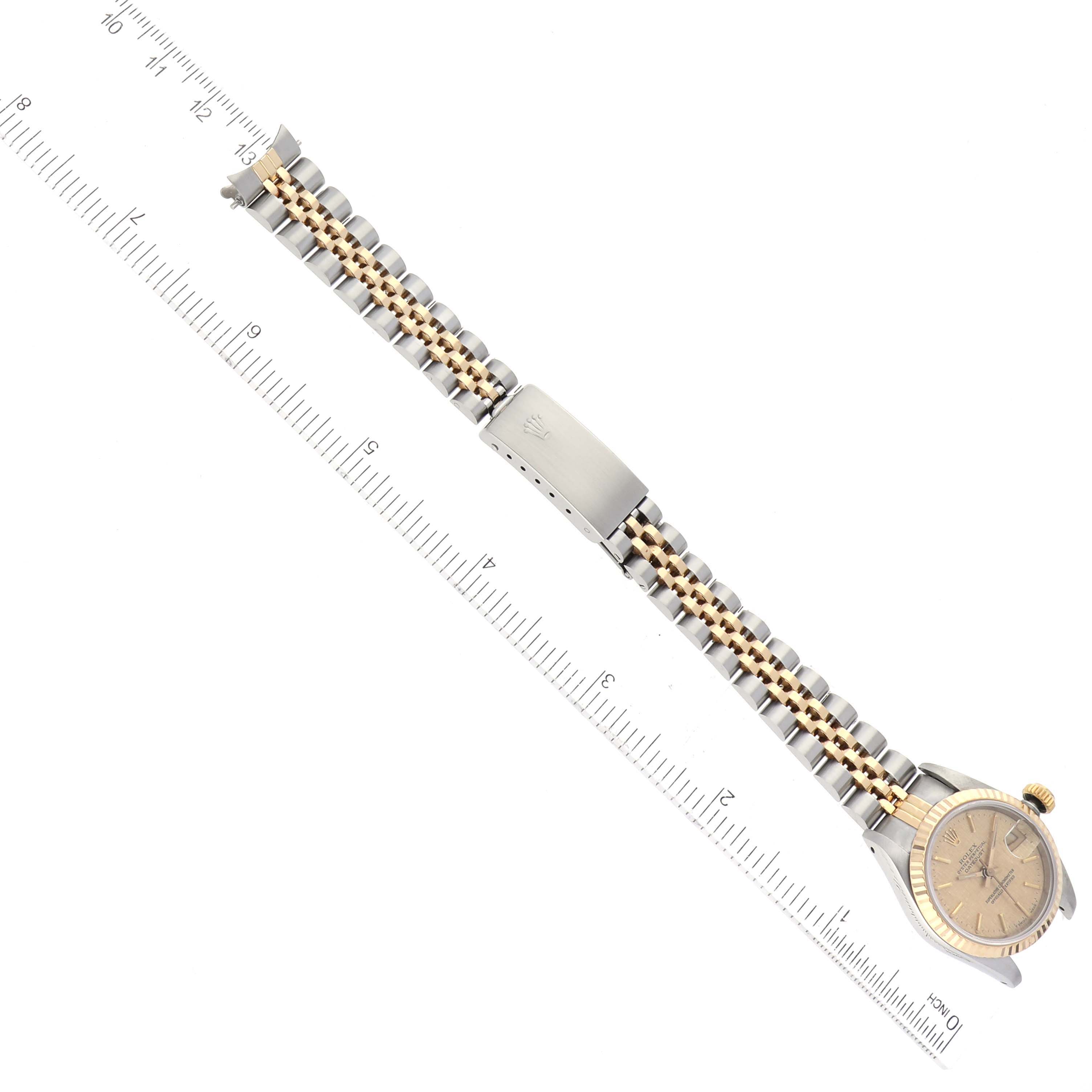 This image shows a full-length Rolex Datejust 69173 Women's Steel and Gold (two tone) Champagne Dial 69173 Women's Steel and Gold (two tone) Champagne Dial watch with a ruler for scale, showcasing the front face and bracelet.