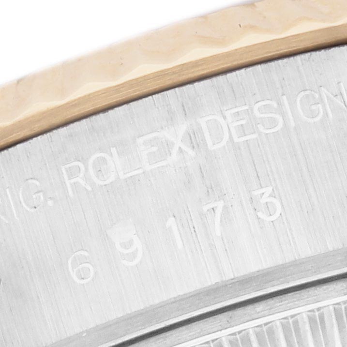 The image shows a close-up of the side of a Rolex Datejust 69173 Women's Steel and Gold (two tone) Champagne Dial 69173 Women's Steel and Gold (two tone) Champagne Dial, highlighting the bezel and engraved serial numbers.