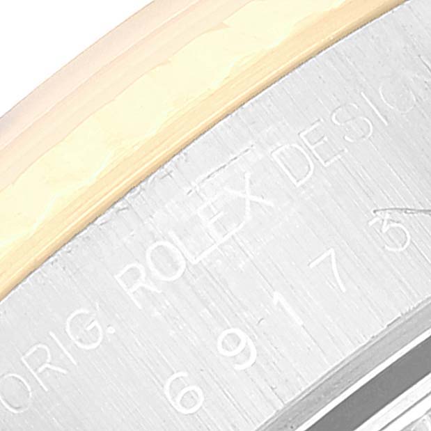 This close-up image shows the edge of the watch case with engraved text on a Rolex Datejust 69173 Women's Steel and Gold (two tone) Champagne Dial 69173 Women's Steel and Gold (two tone) Champagne Dial model.
