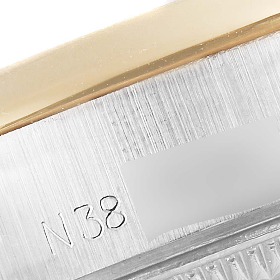 This close-up image of a Rolex Datejust 69163 Women's Steel and Gold (two tone) Grey Dial 69163 Women's Steel and Gold (two tone) Grey Dial watch shows the case side with the serial number engraved.