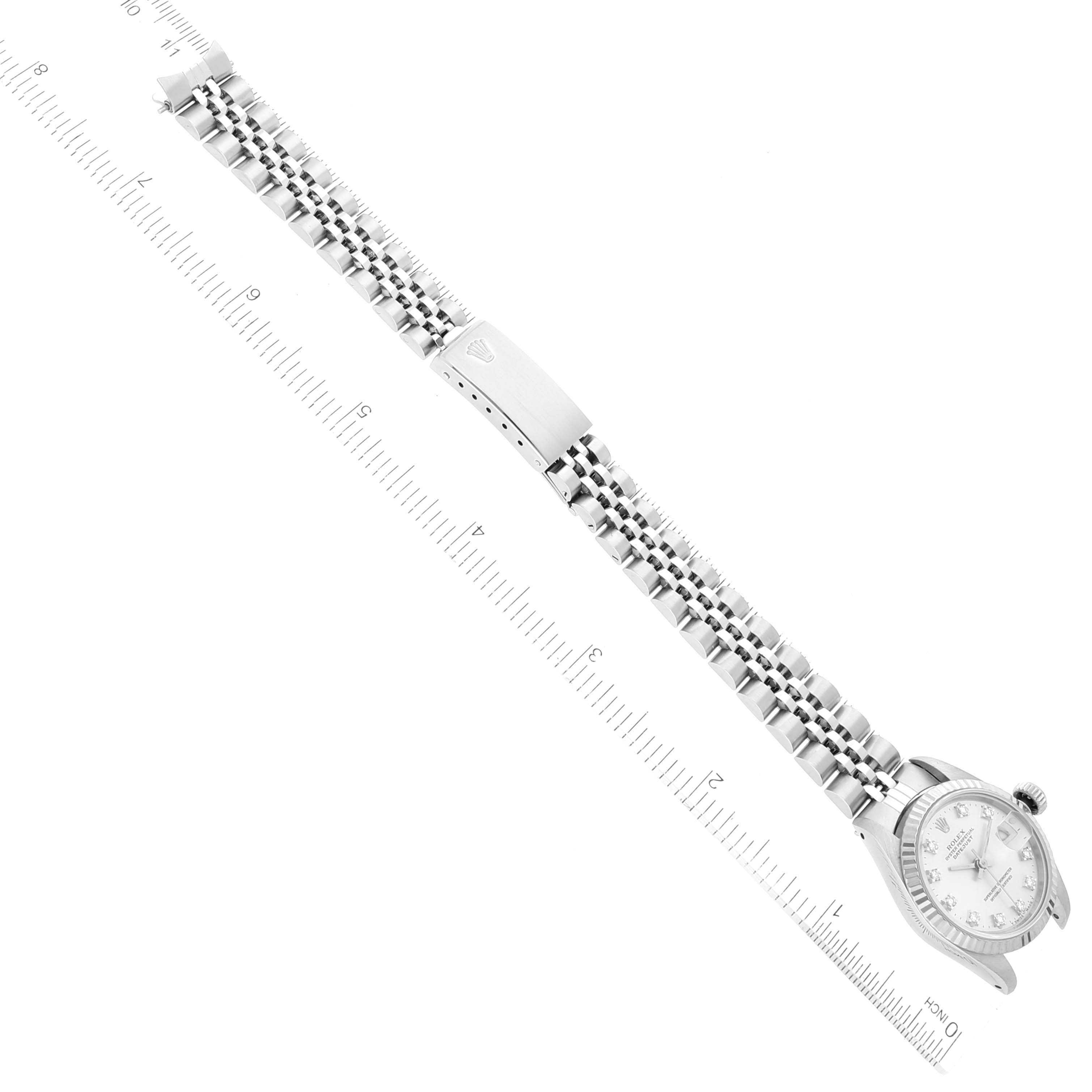 The image shows a top-down view of a Rolex Datejust 69174 Women's Stainless Steel Silver Dial 69174 Women's Stainless Steel Silver Dial watch with its full bracelet extended alongside a ruler.