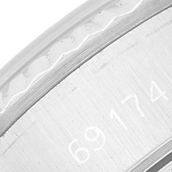The image shows a close-up of the Rolex Datejust 69174 Women's Stainless Steel Silver Dial 69174 Women's Stainless Steel Silver Dial watch, focusing on the case and part of the engraved serial number.