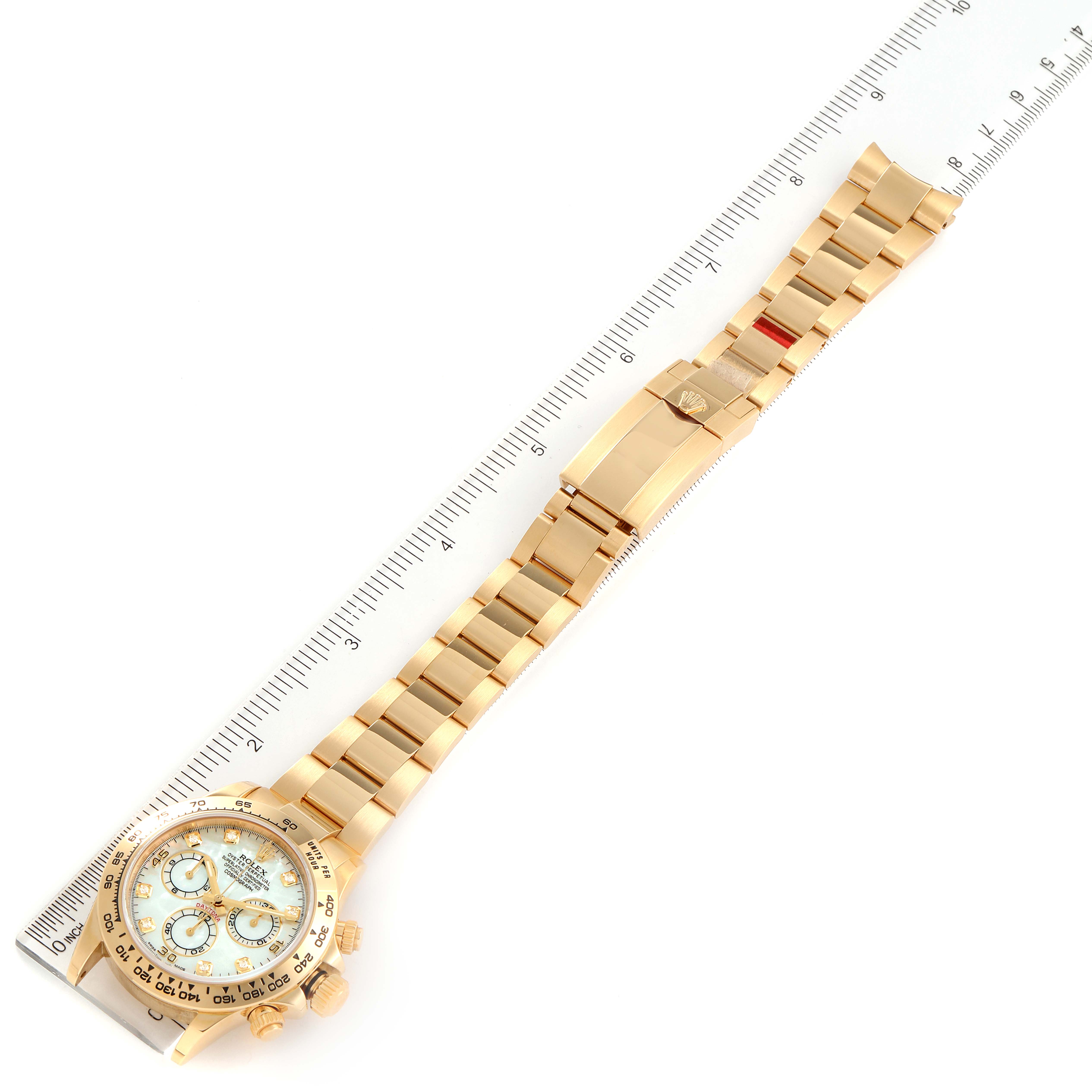 The image displays a gold Rolex Daytona 116508 Men's Yellow Gold Mother of Pearl Dial 116508 Men's Yellow Gold Mother of Pearl Dial watch laying flat with its band extended, alongside a ruler for scale.