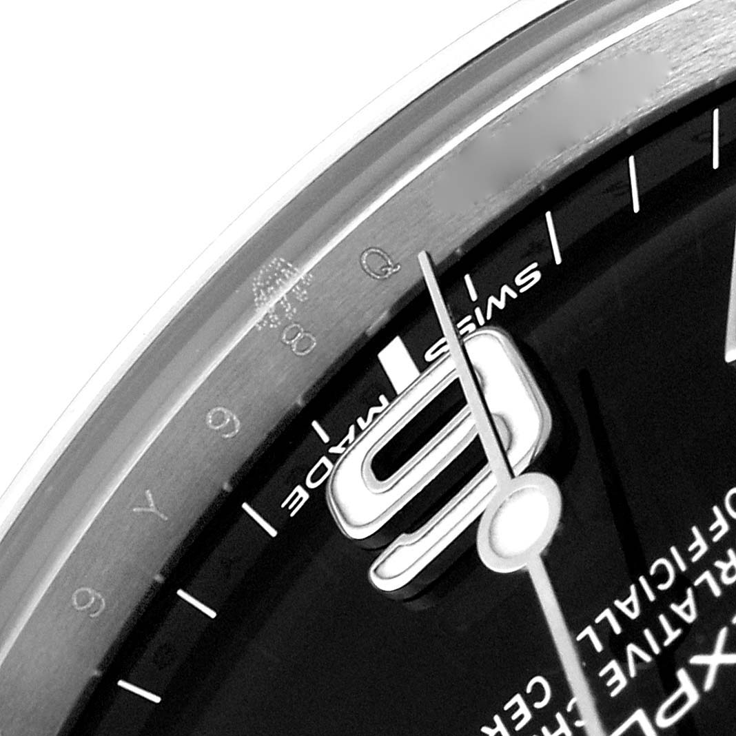 Close-up of a Rolex Explorer 214270 Men's Stainless Steel Black Dial 214270 Men's Stainless Steel Black Dial dial showing the number 9, hands, and part of the outer bezel.