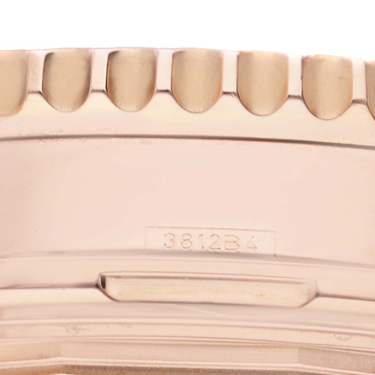 The image shows a close-up of the bezel and case side of a Breitling Navitimer RB0120 Men
s Rose Gold Black Dial RB0120 Men
s Rose Gold Black Dial watch with a visible serial number, 3812B4.