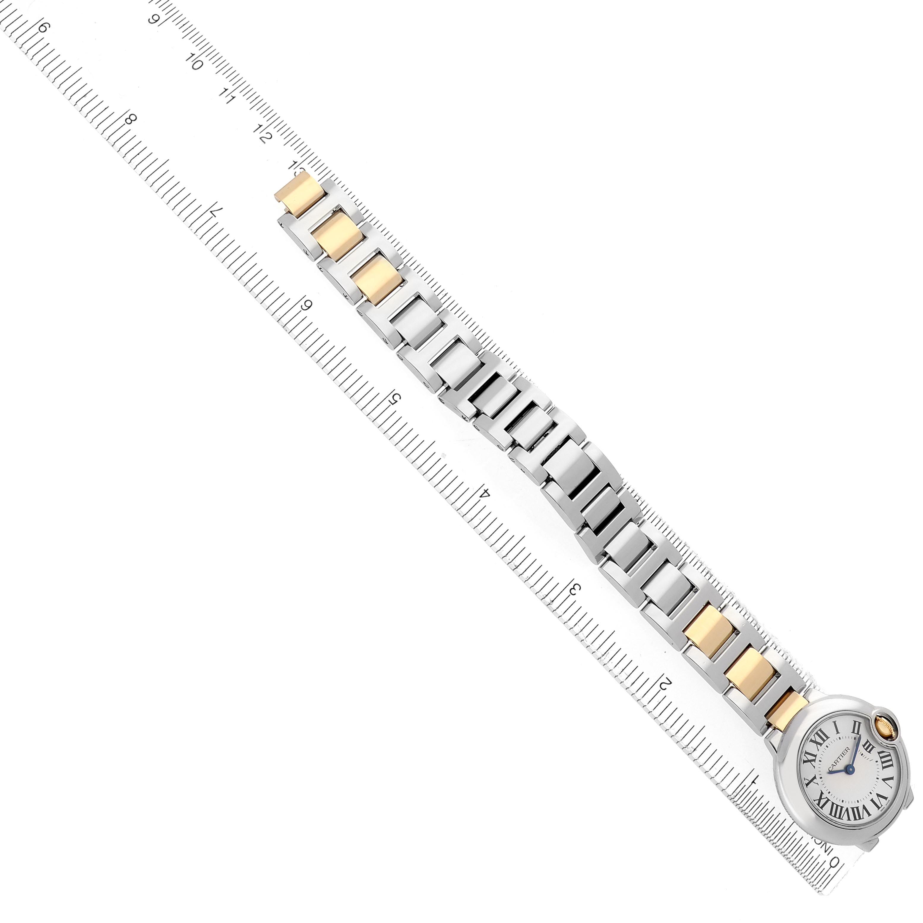 The image shows the Ballon Bleu by Cartier, displaying the watch face and full bracelet against a ruler at a slanted angle.