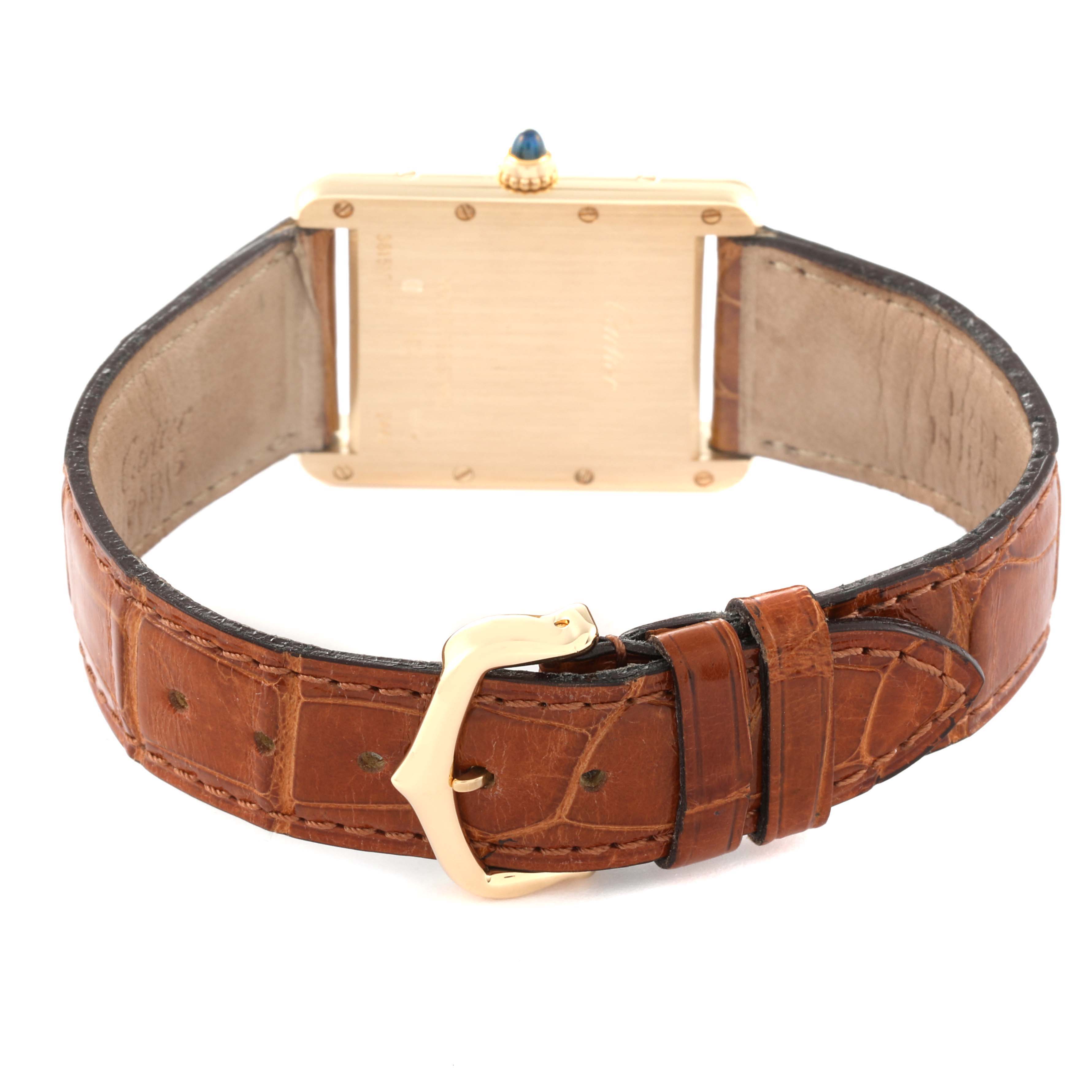 The image shows the rear view of a Tank Louis model watch by Cartier, highlighting its strap, gold buckle, and case back.