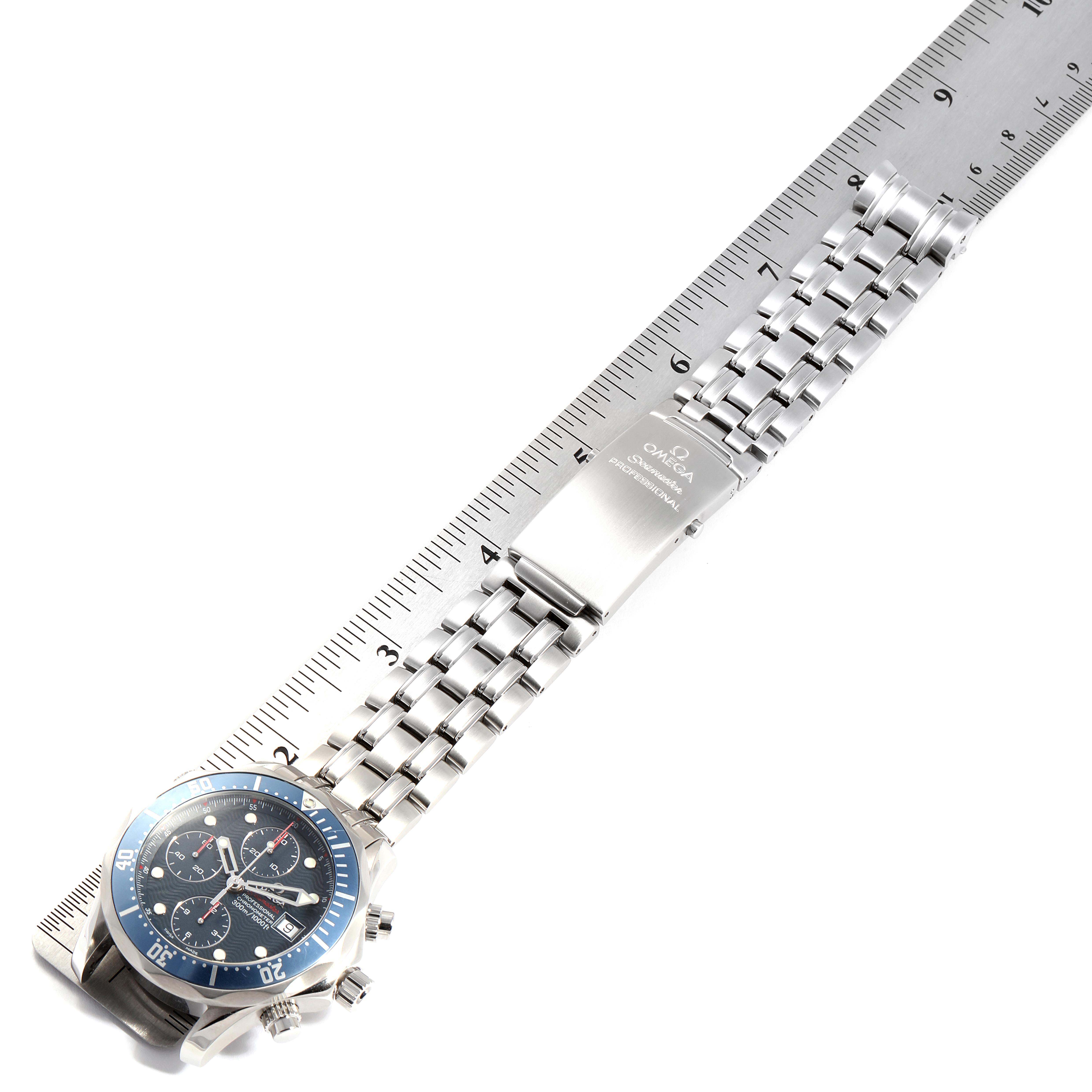 The image shows an Omega Seamaster 2225.80.00 Men
s Stainless Steel Blue Dial 2225.80.00 Men
s Stainless Steel Blue Dial watch laid flat against a ruler, displaying the face, bracelet, and clasp in a horizontal view.