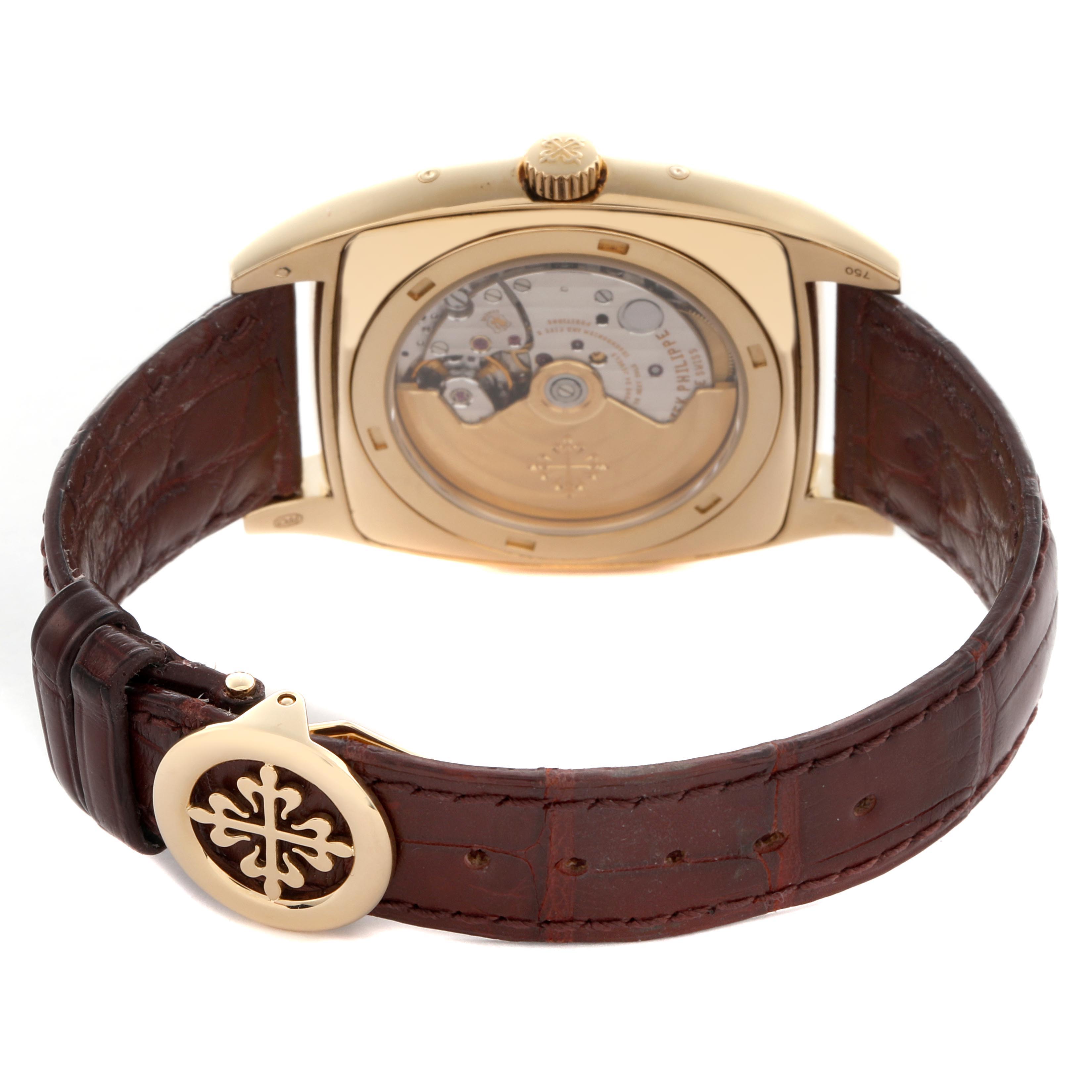 The Patek Philippe Gondolo 5135J-001 Men
s Yellow Gold White Dial 5135J-001 Men
s Yellow Gold White Dial watch is shown from the back, displaying its movement and leather strap with a decorative clasp.