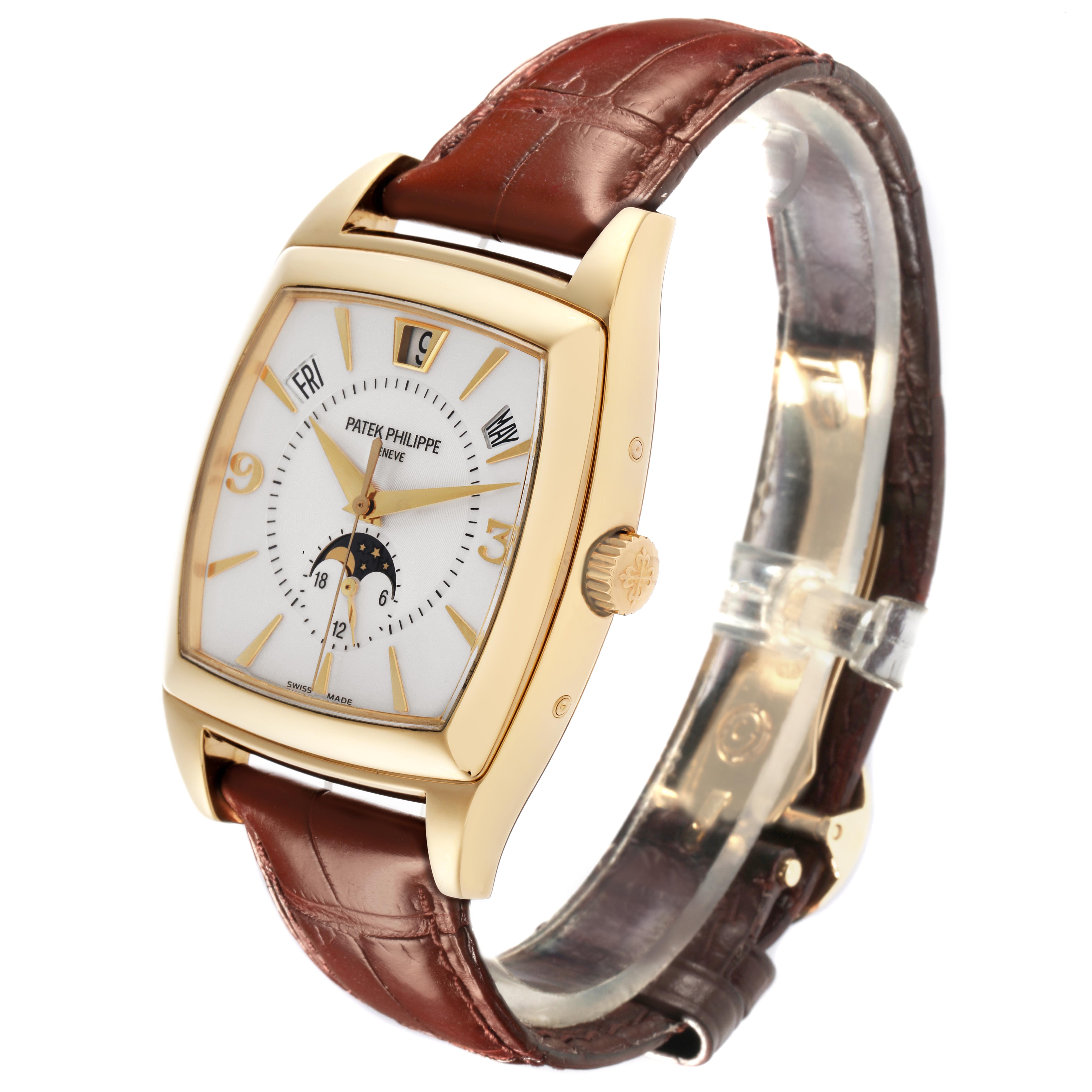 The Patek Philippe Gondolo 5135J-001 Men
s Yellow Gold White Dial 5135J-001 Men
s Yellow Gold White Dial watch is shown at a side angle, highlighting its gold case, dial, and brown leather strap.
