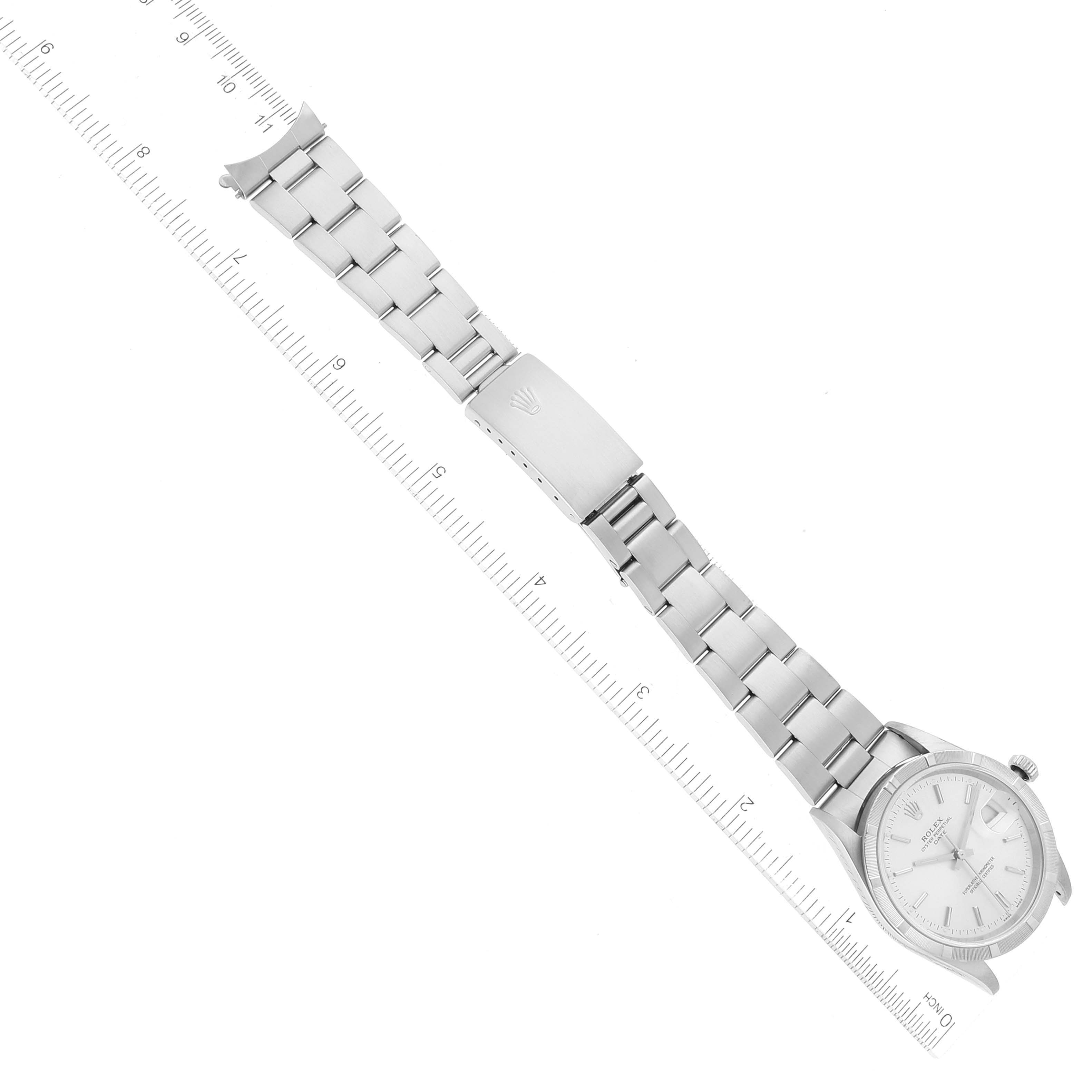 This image shows the Rolex Date 15210 Men's Stainless Steel Silver Dial 15210 Men's Stainless Steel Silver Dial model watch laid flat, with a ruler alongside it for measurement.