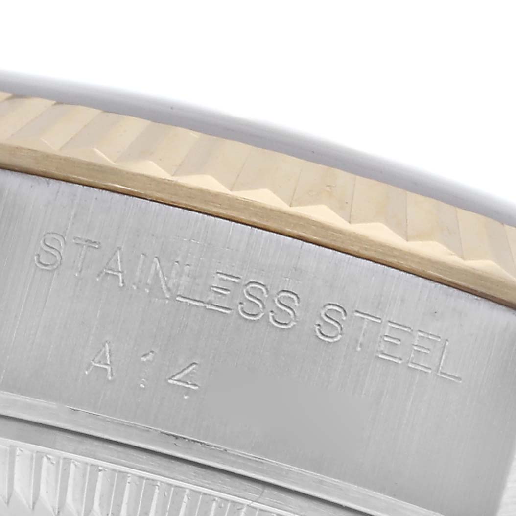 The image shows a close-up of the side of a Rolex Datejust 69173 Women's Steel and Gold (two tone) Champagne Dial 69173 Women's Steel and Gold (two tone) Champagne Dial, focusing on the etched text "STAINLESS STEEL" on the case and the fluted bezel.