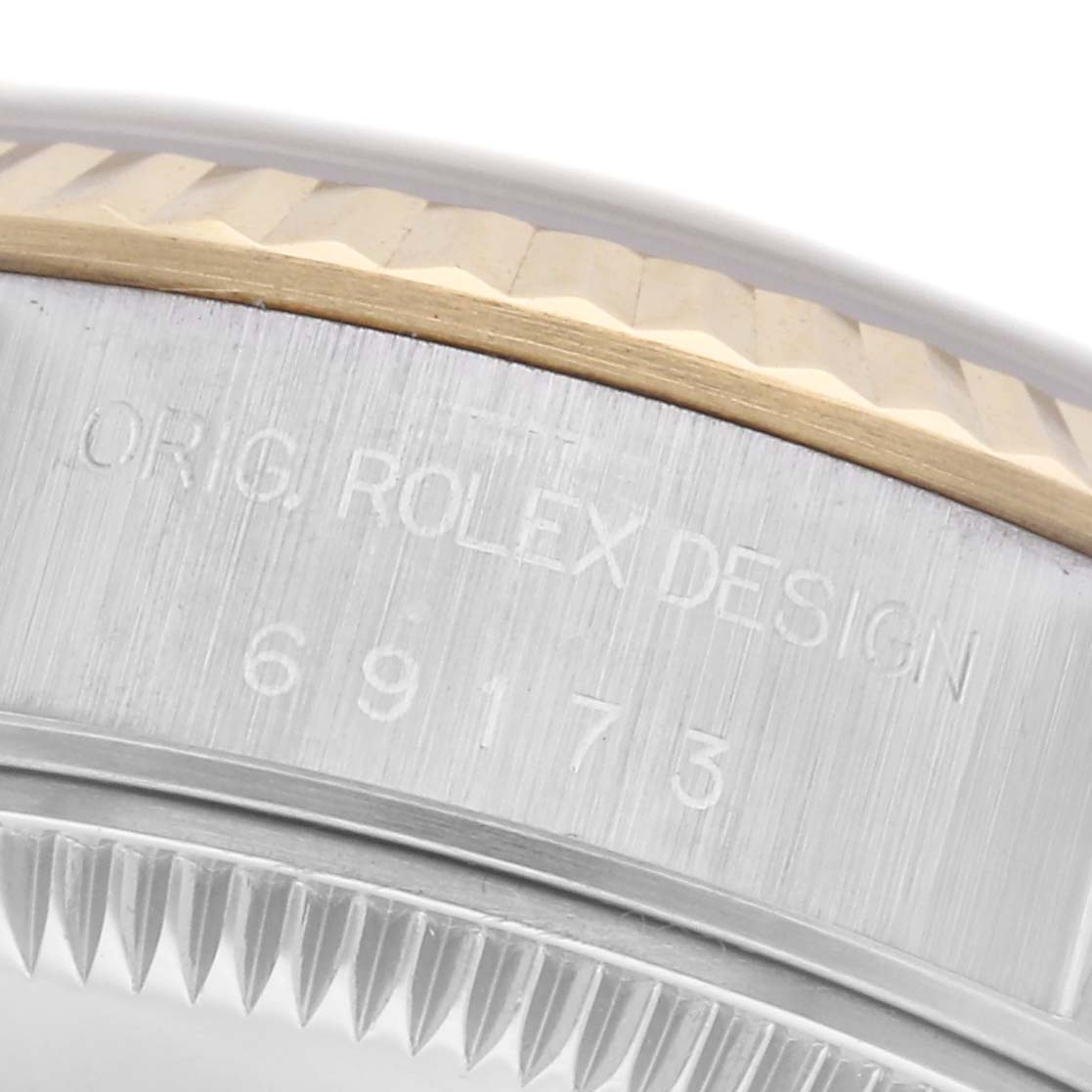 The image shows a close-up of the side of a Rolex Datejust 69173 Women's Steel and Gold (two tone) Champagne Dial 69173 Women's Steel and Gold (two tone) Champagne Dial, focusing on the bezel and engraved case details.
