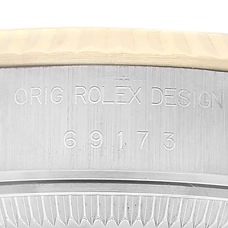 This close-up image shows the model number and "Orig Rolex Design" engraving on the Rolex Datejust 69173 Women's Steel and Gold (two tone) Champagne Dial 69173 Women's Steel and Gold (two tone) Champagne Dial watch case.