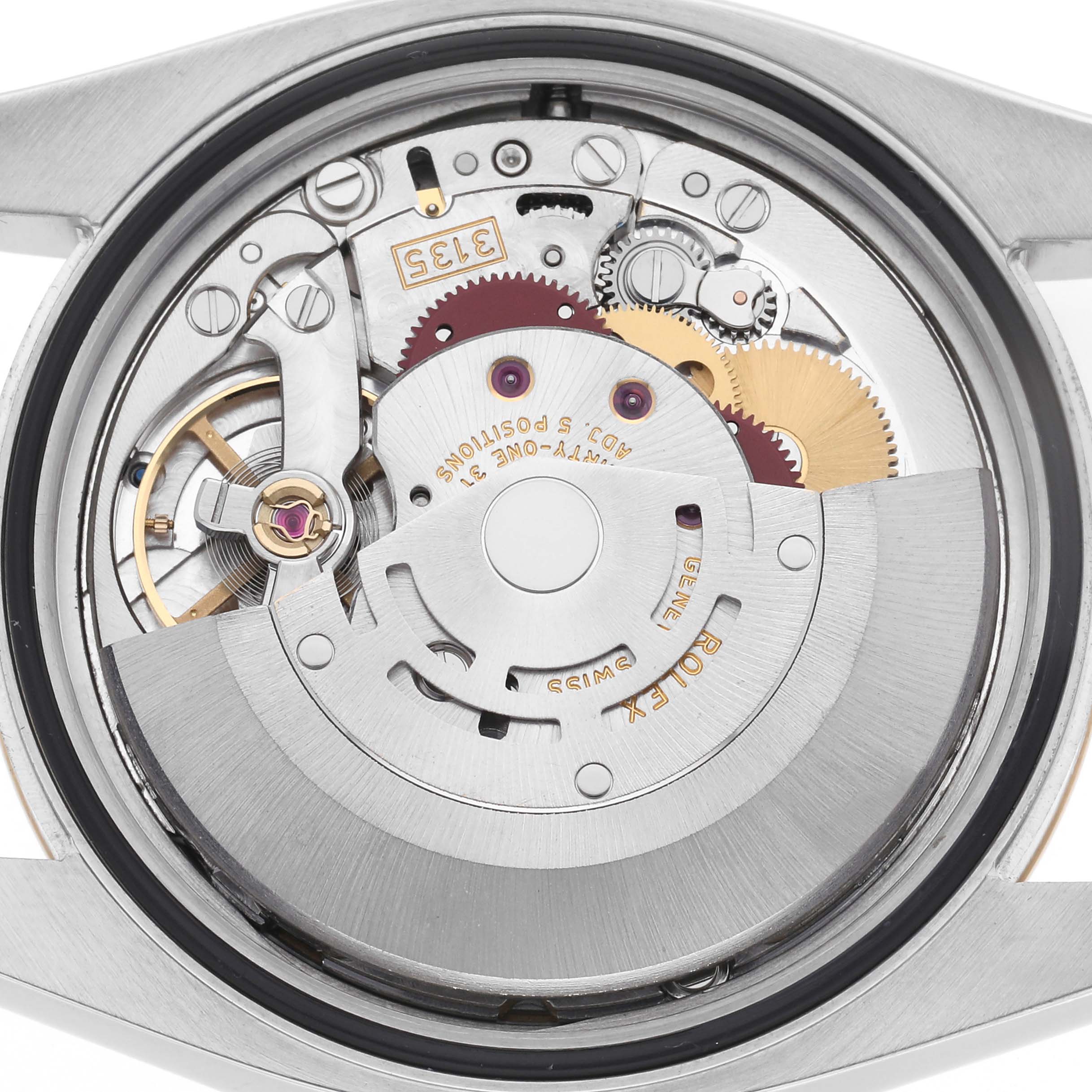 The image shows the back of a Rolex Datejust 116233 Men
s Steel and Gold (two tone) White Dial 116233 Men
s Steel and Gold (two tone) White Dial, revealing its intricate internal movement and gears.