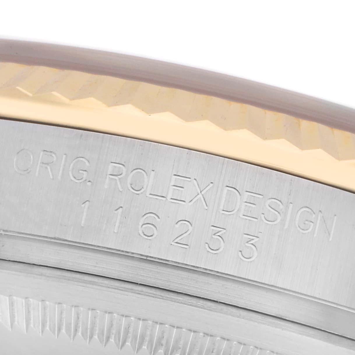 The image shows a close-up of the side of a Rolex Datejust 116233 Men
s Steel and Gold (two tone) White Dial 116233 Men
s Steel and Gold (two tone) White Dial, highlighting the engraved bezel and case reference number.
