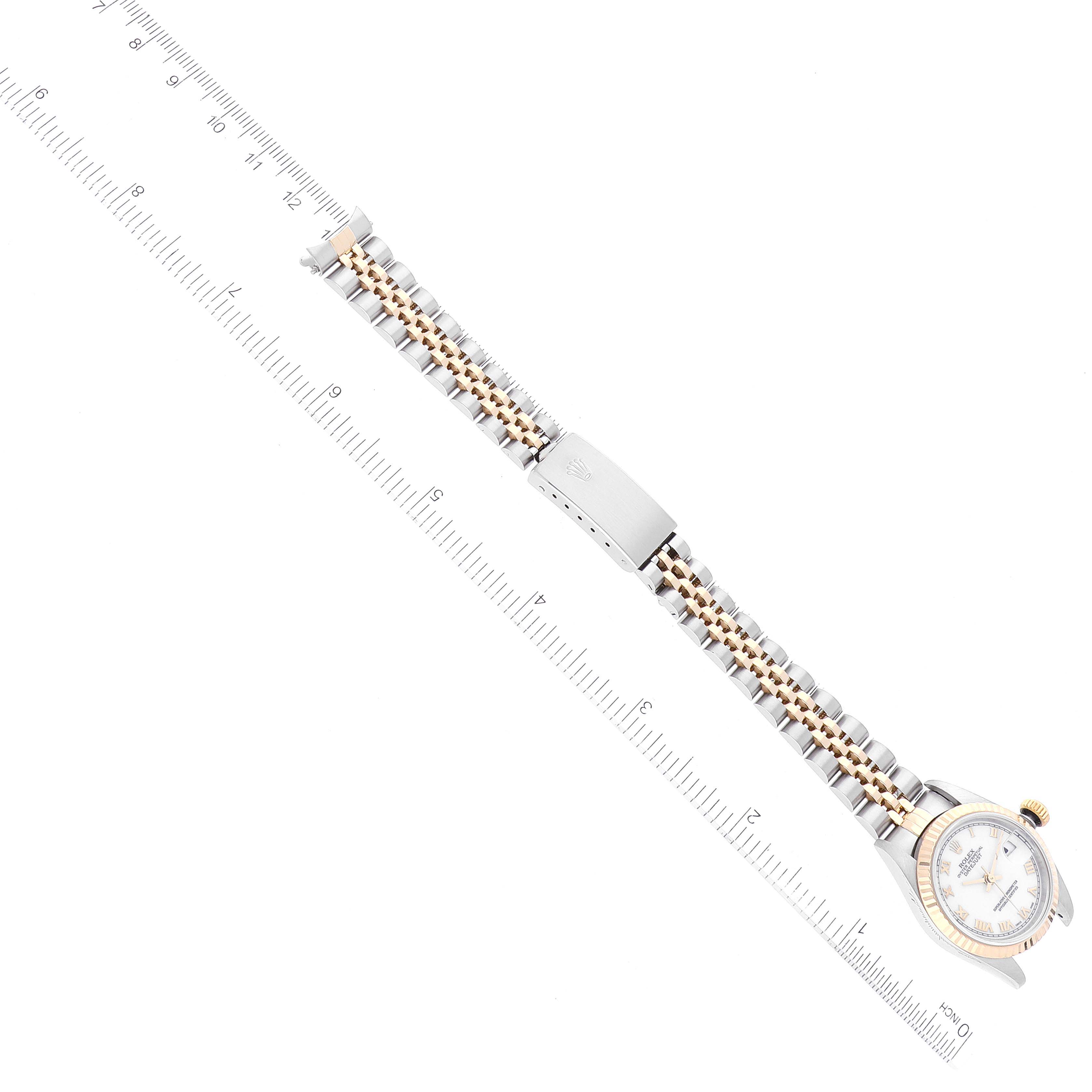 The Rolex Datejust 79173 Women's Steel and Gold (two tone) White Dial 79173 Women's Steel and Gold (two tone) White Dial watch is shown from a top-down angle, highlighting the face, bracelet, and clasp alongside a measuring ruler.