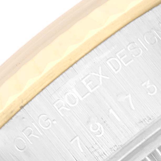 This image shows a close-up of the bezel and edge of the case of a Rolex Datejust 79173 Women's Steel and Gold (two tone) White Dial 79173 Women's Steel and Gold (two tone) White Dial, highlighting the engraved design information.