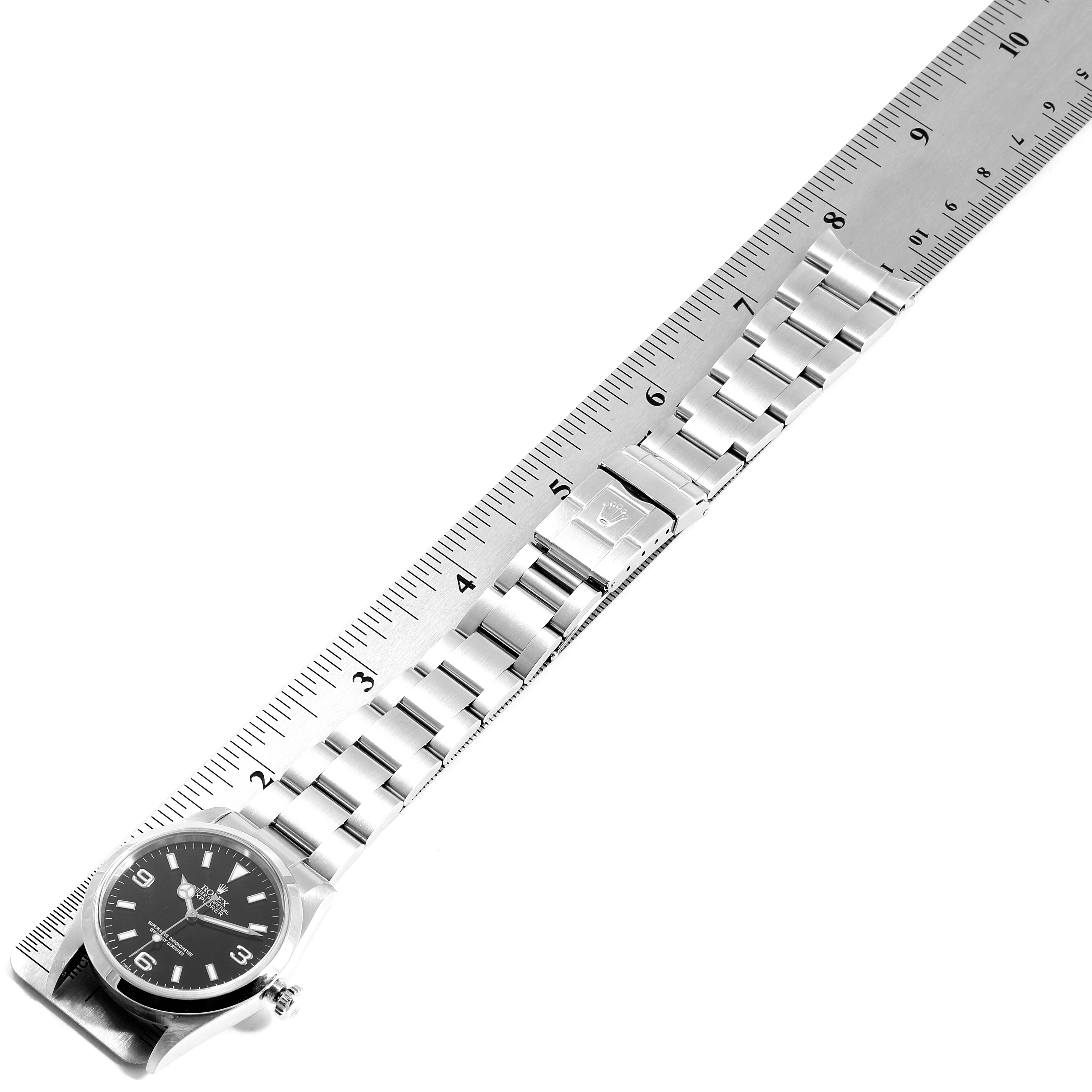 The image shows a Rolex Explorer 114270 Men
s Stainless Steel Black Dial 114270 Men
s Stainless Steel Black Dial watch, side view, with its bracelet extended and measured against a ruler.