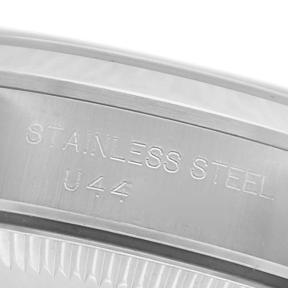 The image shows a close-up of the side of the Rolex Oyster Perpetual 67180 Women's Stainless Steel Pink Dial 67180 Women's Stainless Steel Pink Dial case, highlighting the "Stainless Steel" engraving.