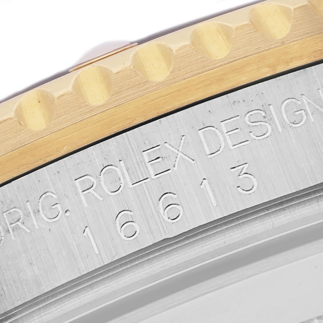 The image shows a close-up of the Rolex Submariner 16613 Men
s Steel and Gold (two tone) Champagne Dial 16613 Men
s Steel and Gold (two tone) Champagne Dial
s engraved case side and bezel edge.