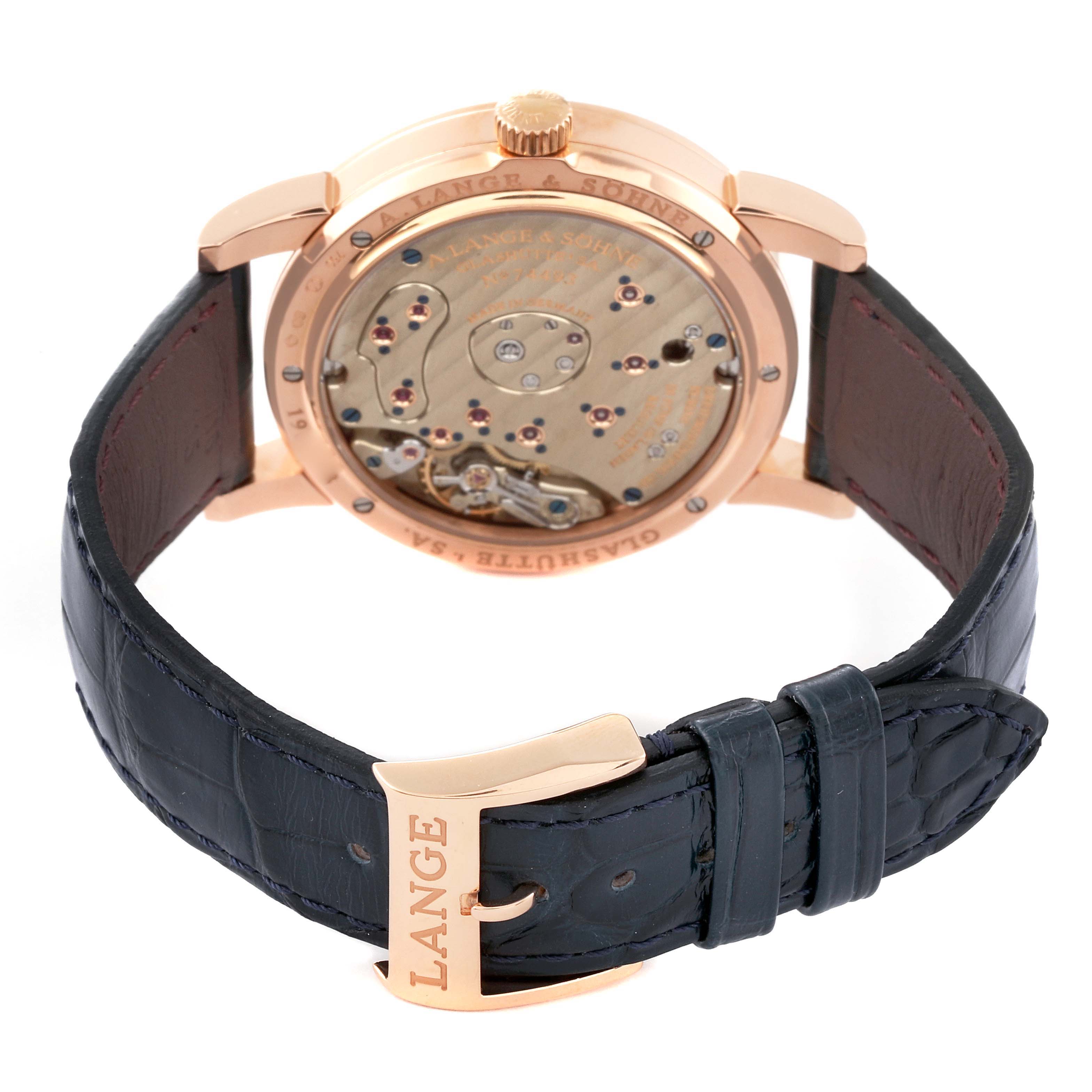 The image shows the back view of the A. Lange & Sohne Lange 1 101.032 Men's Rose Gold Silver Dial watch, highlighting its movement and leather strap.