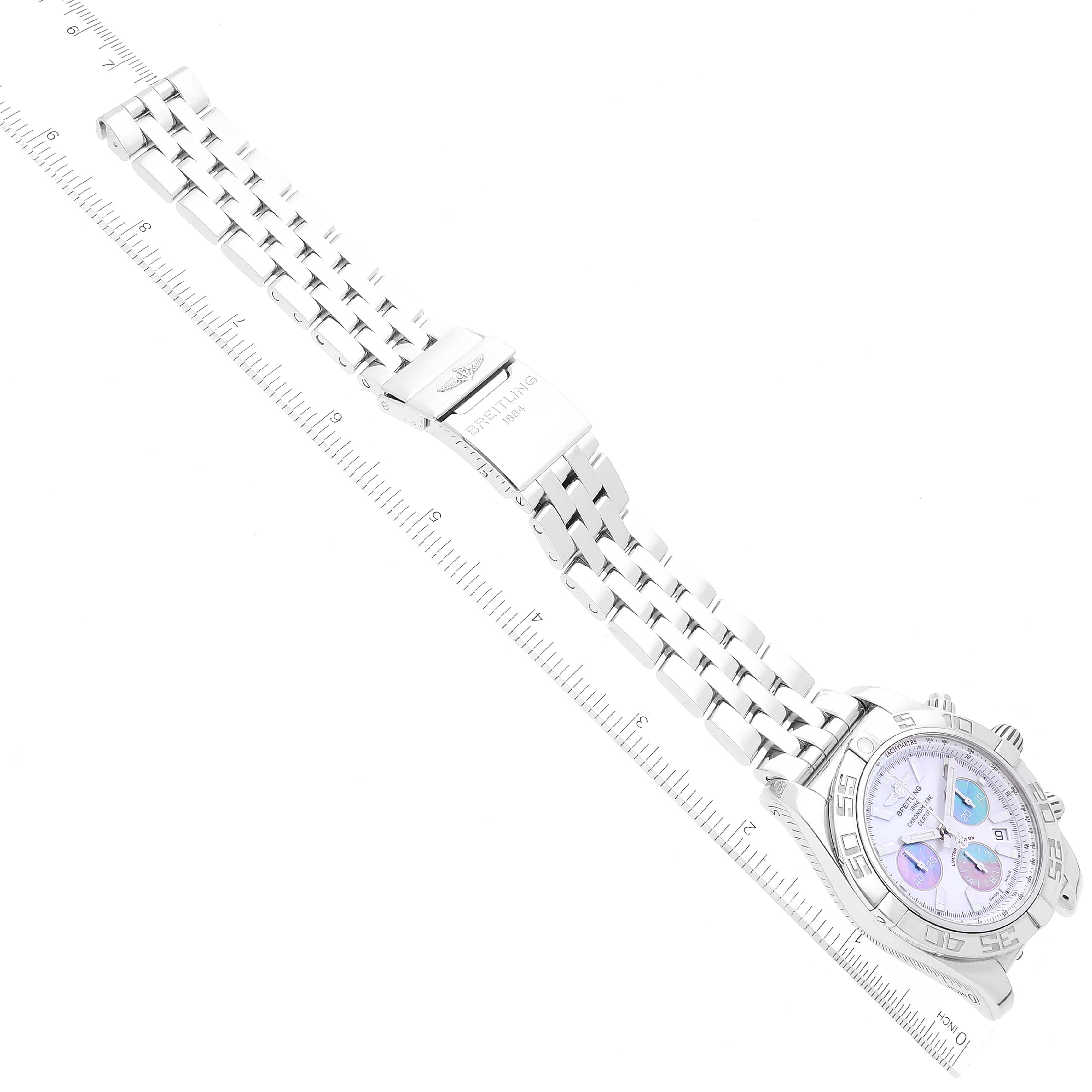 The Breitling Chronomat AB0110 Men
s Stainless Steel Mother of Pearl Dial AB0110 Men
s Stainless Steel Mother of Pearl Dial watch is shown from a top-down angle, displaying the face, case, bracelet, and clasp adjacent to a ruler.