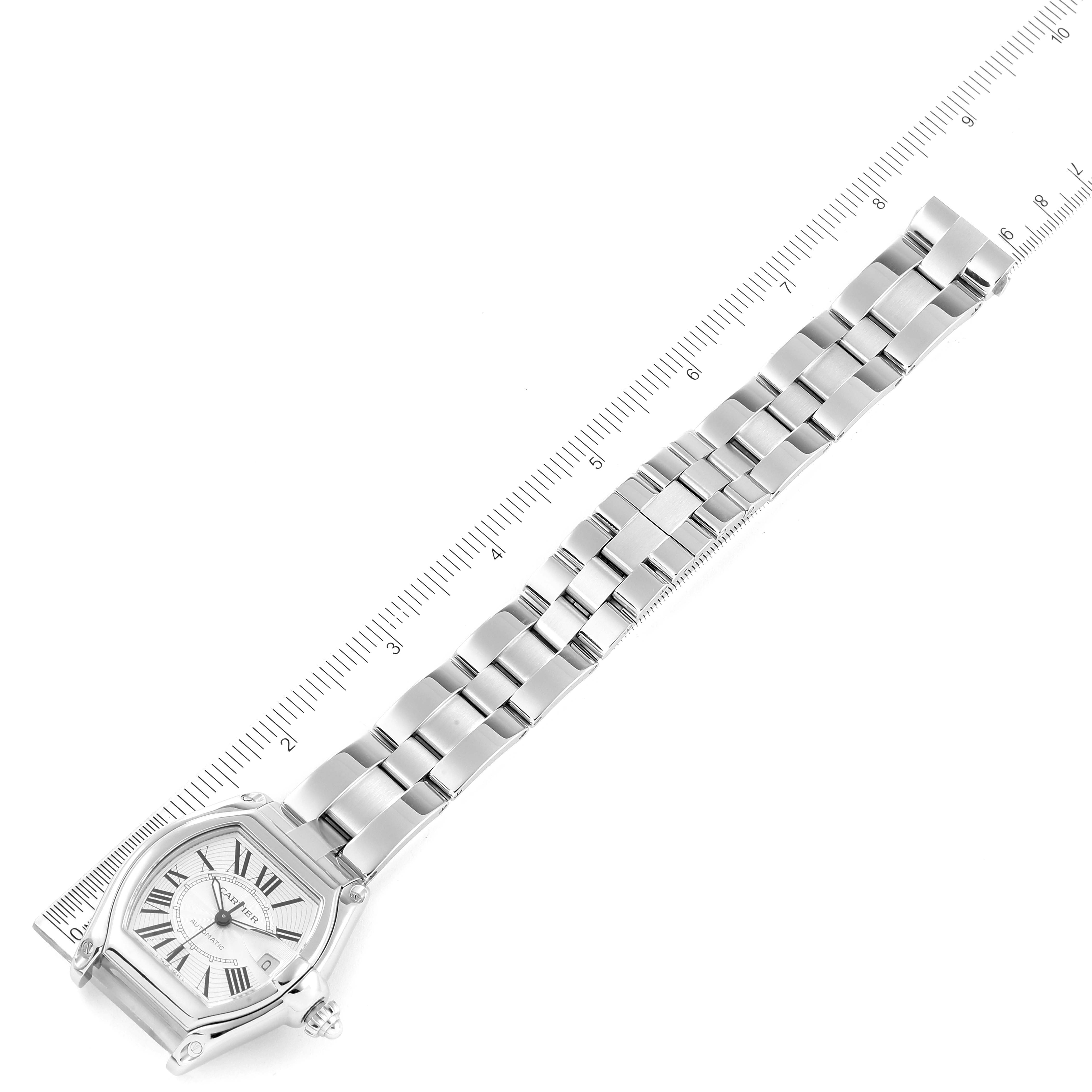 The Cartier Roadster W62025V3 Men
s Stainless Steel Silver Dial W62025V3 Men
s Stainless Steel Silver Dial model watch is shown from a top angle, displaying its face and metal link bracelet against a ruler.