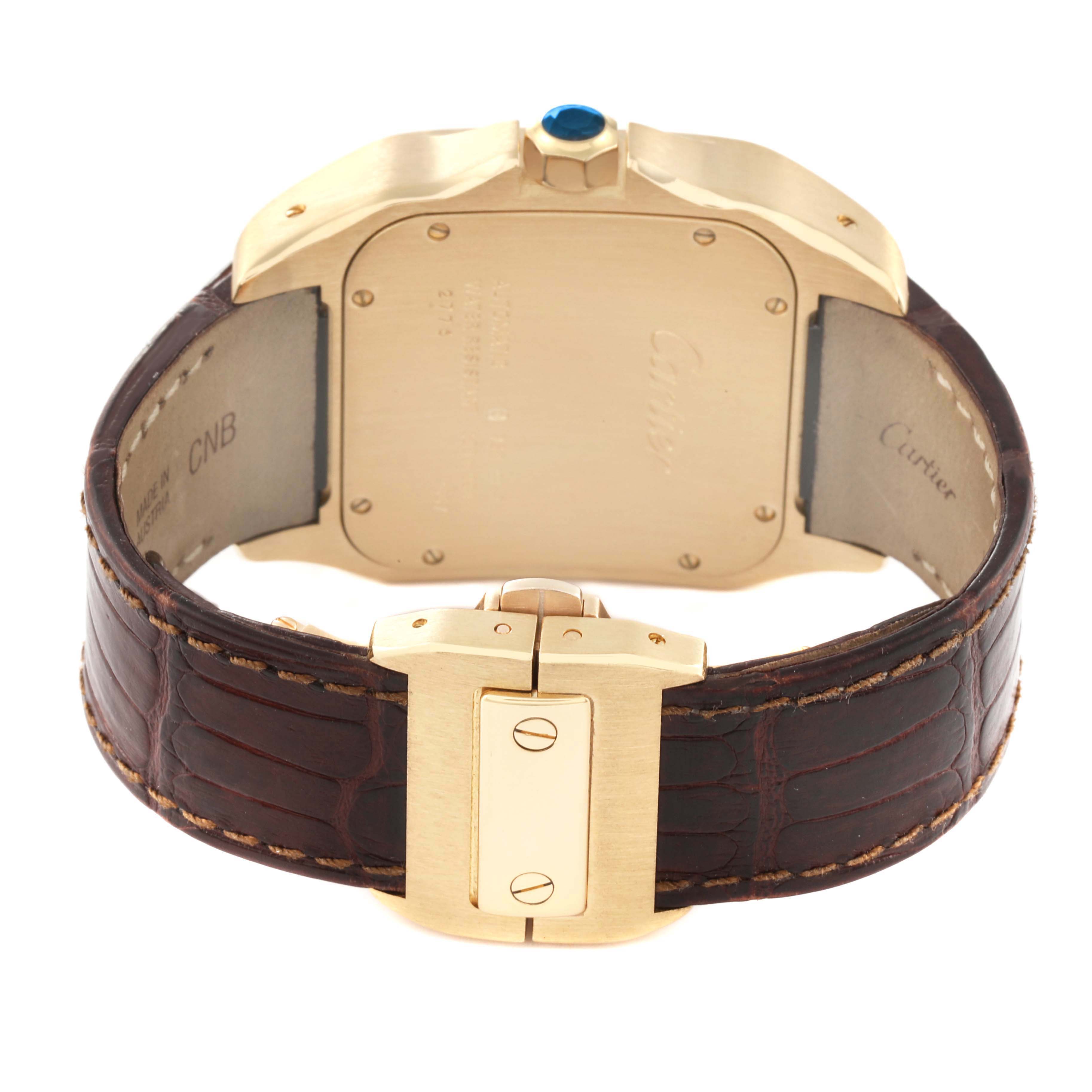 The image shows the back view of the Santos model watch by Cartier, highlighting the gold case, crown, and leather strap with a clasp.