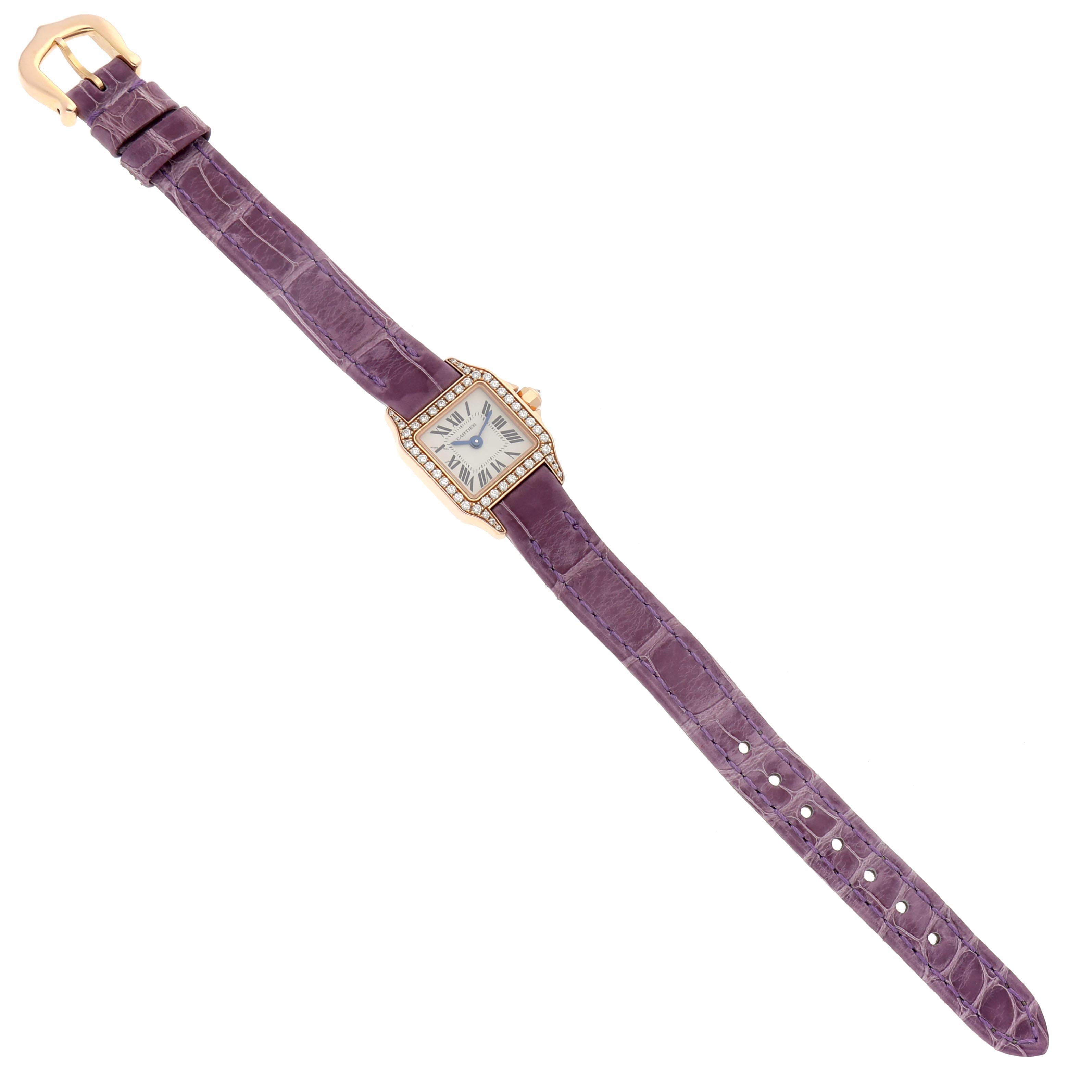 The Cartier Santos Demoiselle WF902004 Women
s Yellow Gold Silver Dial WF902004 Women
s Yellow Gold Silver Dial watch is displayed from a top view, showing the dial, bejeweled bezel, purple strap, and clasp.