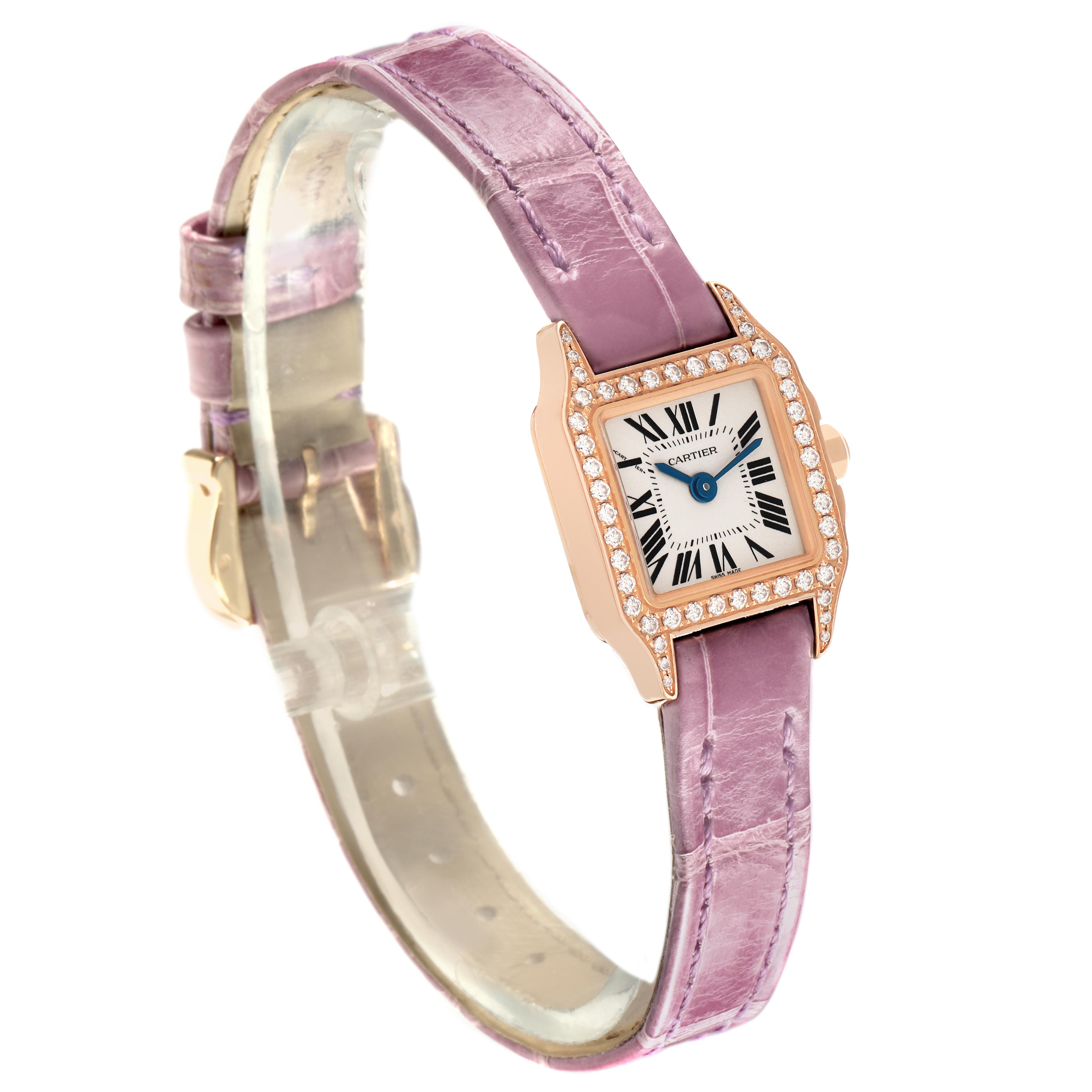 The image shows a Cartier Santos Demoiselle WF902004 Women
s Yellow Gold Silver Dial WF902004 Women
s Yellow Gold Silver Dial watch angled slightly from above, highlighting its pink strap and diamond-set bezel.