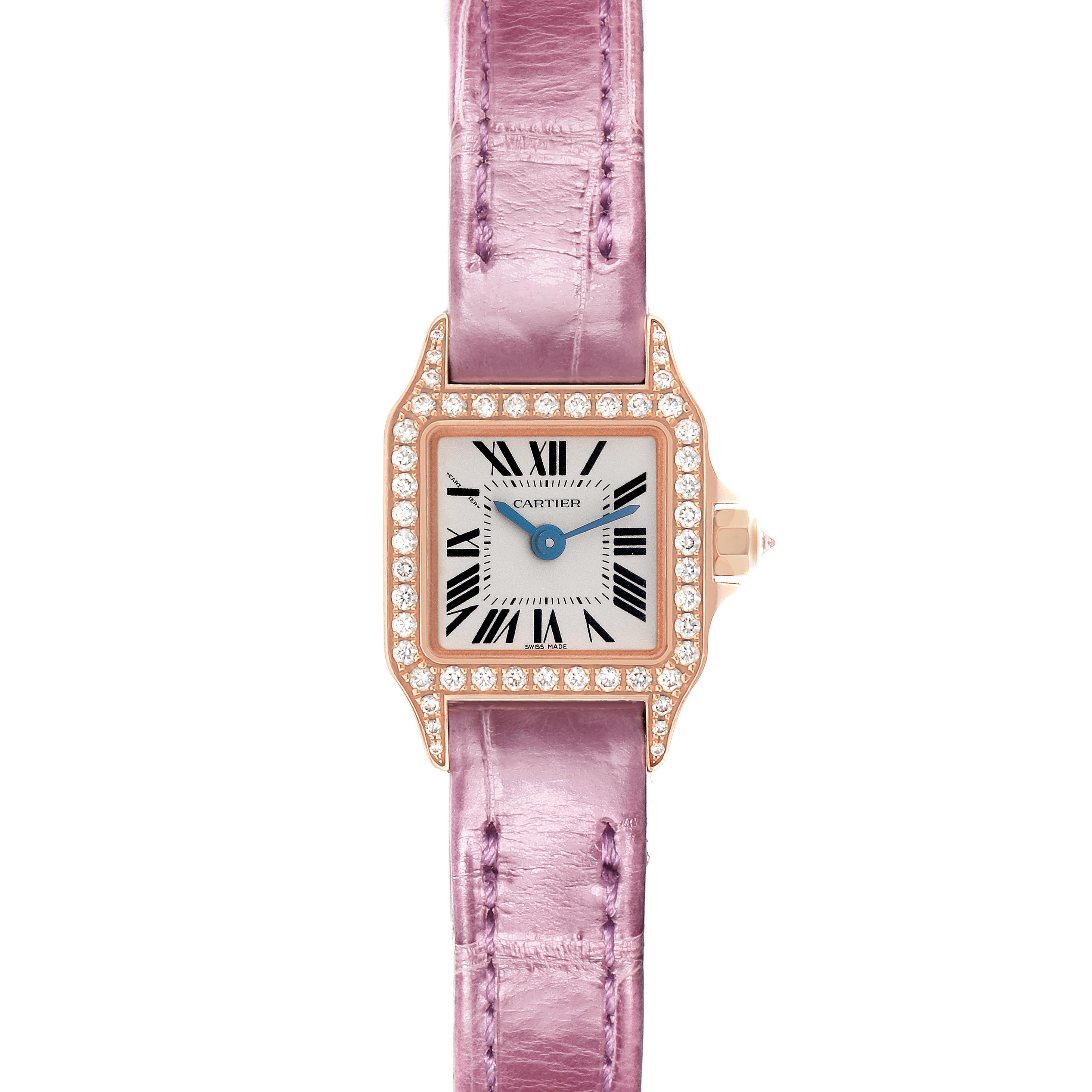 The Cartier Santos Demoiselle WF902004 Women
s Yellow Gold Silver Dial WF902004 Women
s Yellow Gold Silver Dial watch is shown from a top view, featuring a diamond-encrusted bezel and a pink leather strap.