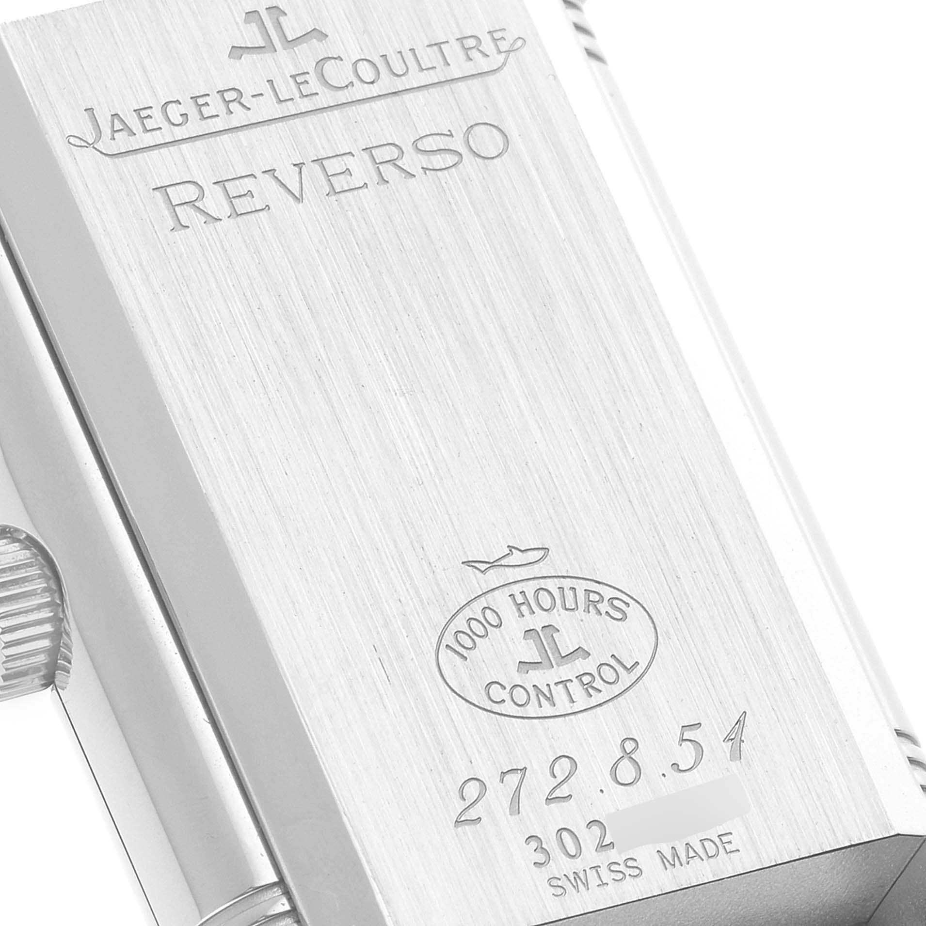 The image shows the back of a Jaeger-LeCoultre Reverso watch, highlighting its engravings and control stamp.