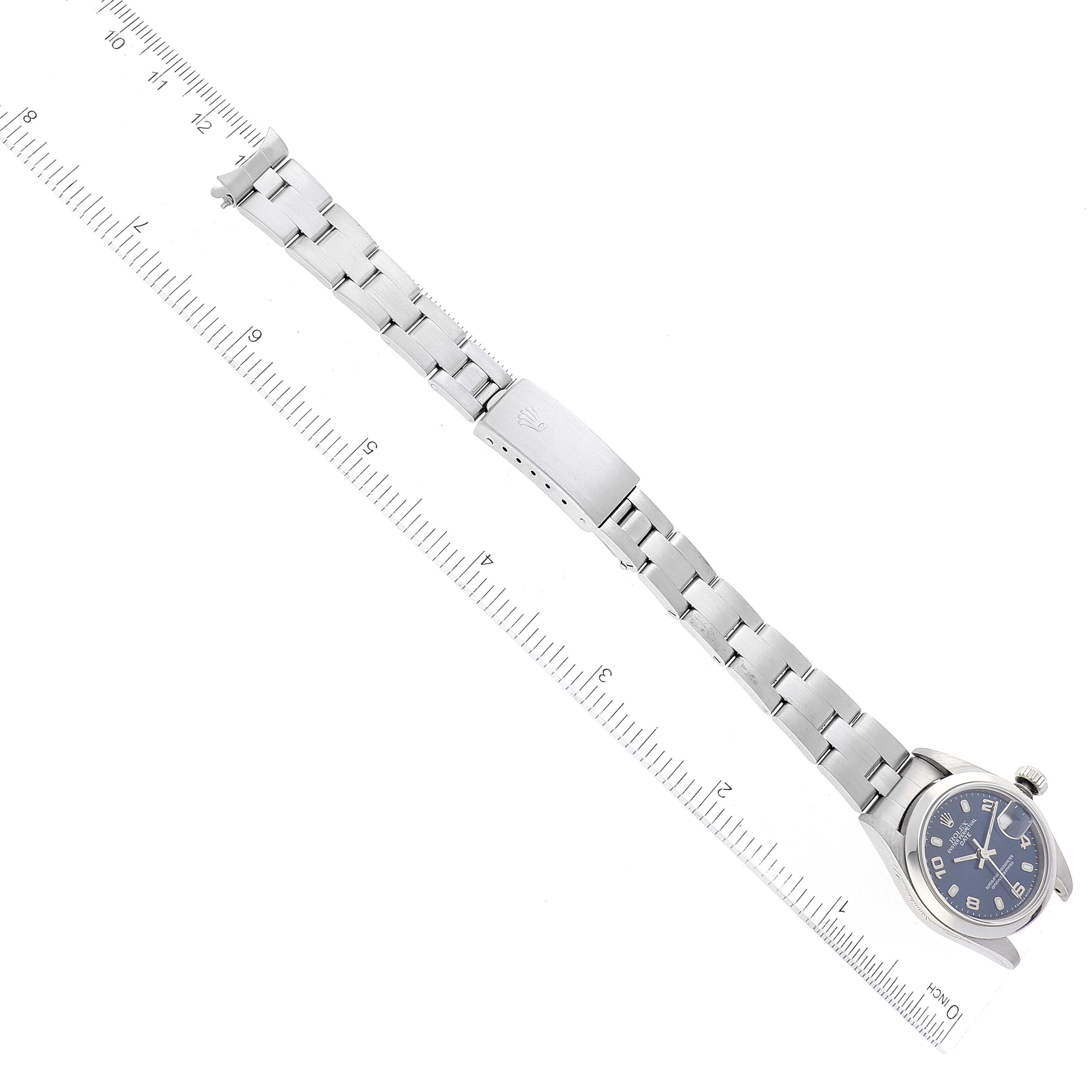 The Rolex Date 69160 Women
s Stainless Steel Blue Dial 69160 Women
s Stainless Steel Blue Dial watch is shown flat, displaying its face, bracelet, and clasp alongside a ruler for size reference.