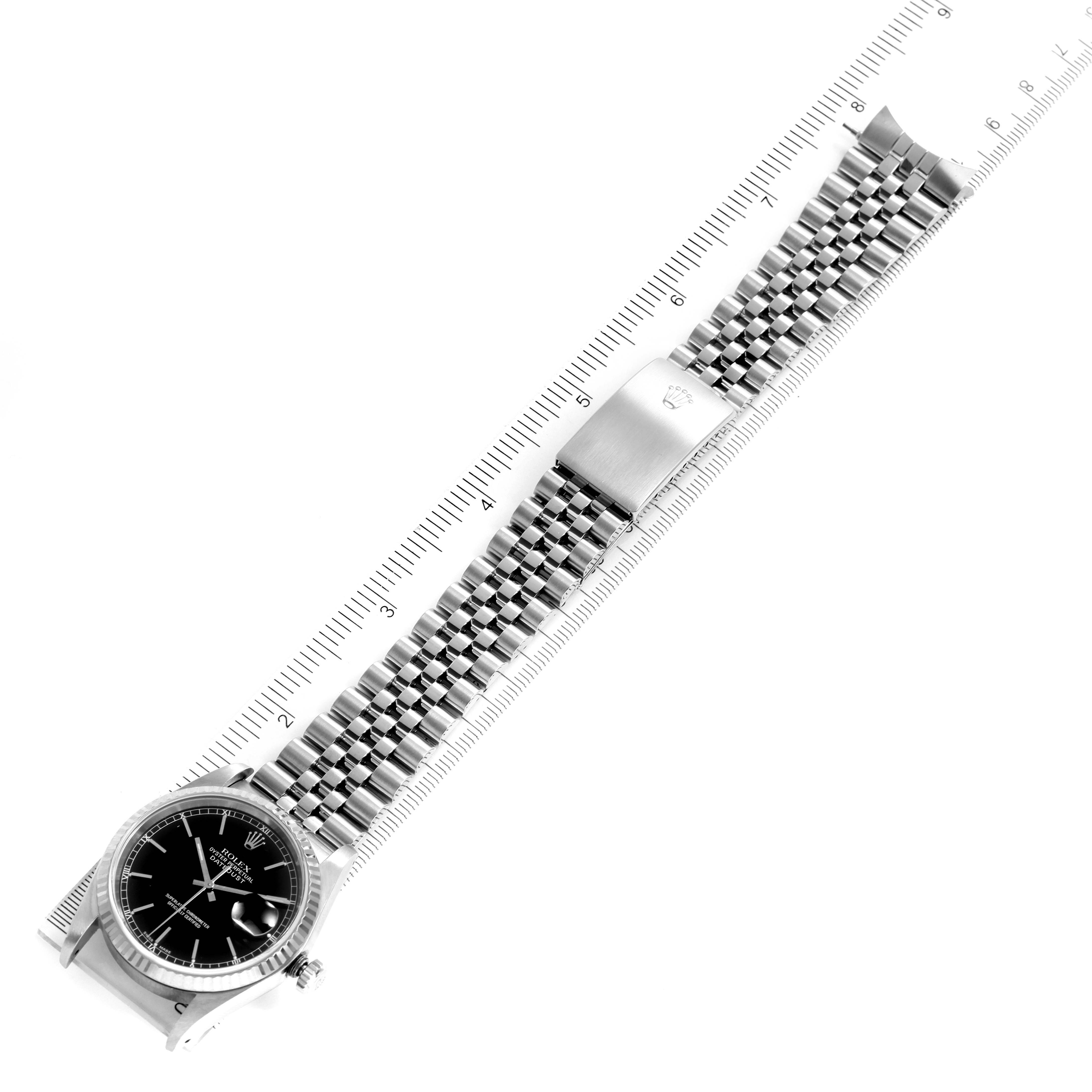 This image shows a Rolex Datejust 16234 Men
s Stainless Steel Black Dial 16234 Men
s Stainless Steel Black Dial watch from an overhead angle, highlighting the face, crown, and bracelet with a ruler for scale.