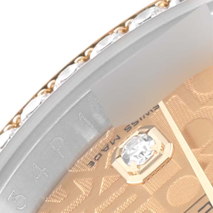 This close-up image of a Rolex Datejust 116243 Men's Steel and Gold (two tone) Champagne Dial 116243 Men's Steel and Gold (two tone) Champagne Dial watch shows the edge of the dial, a diamond, part of the bezel, and the "Swiss Made" text.
