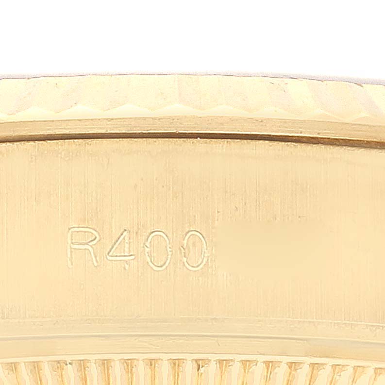 This close-up image shows the side of a Rolex President 69178 Women's Yellow Gold Champagne Dial 69178 Women's Yellow Gold Champagne Dial model watch case, highlighting the engraving.