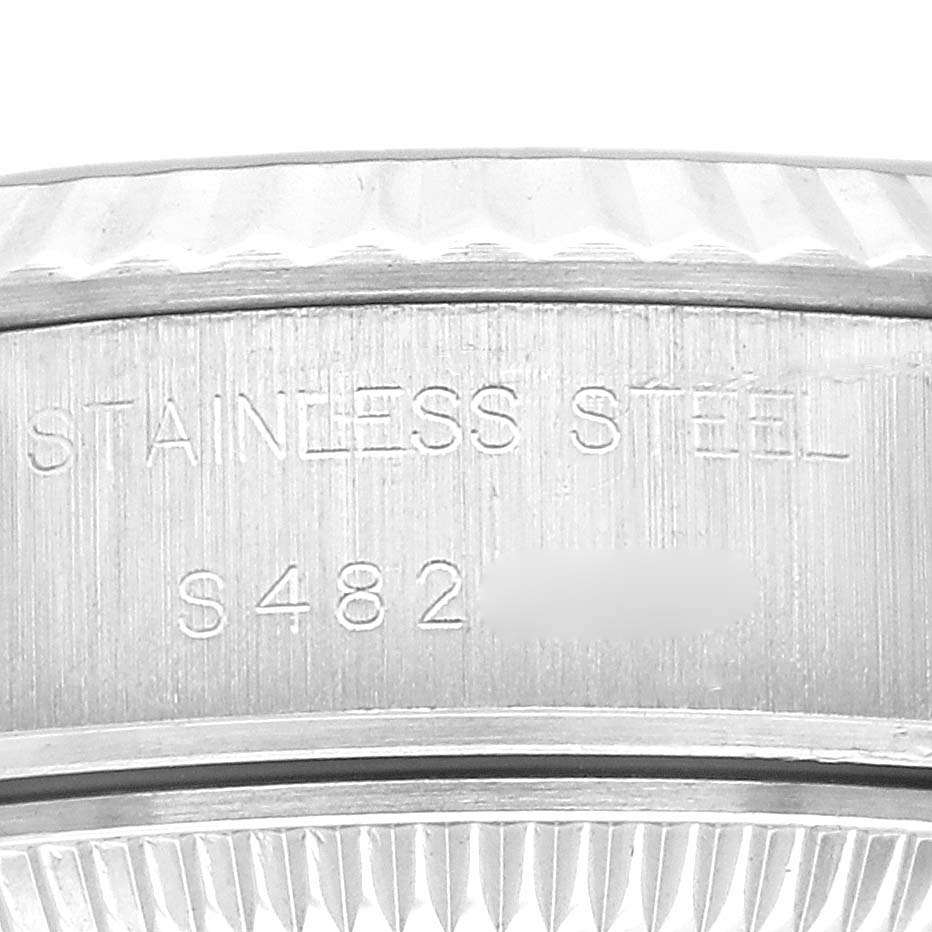 This close-up image of a Rolex Datejust 69174 Women's Stainless Steel Silver Dial 69174 Women's Stainless Steel Silver Dial watch displays the engraving on the casing with "STAINLESS STEEL" and a partial serial number.