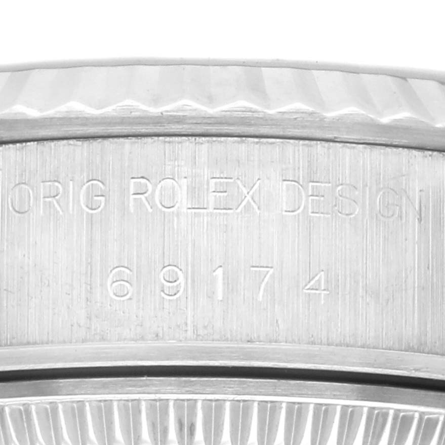 This close-up of the Rolex Datejust 69174 Women's Stainless Steel Silver Dial 69174 Women's Stainless Steel Silver Dial watch shows its case side with engraved serial numbers and part of the bezel.
