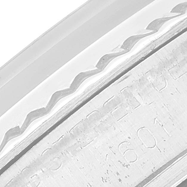 This image shows a close-up of the Rolex Vintage Collection 1601 Men's Stainless Steel Silver Dial 1601 Men's Stainless Steel Silver Dial watch bezel and part of the case side with engraved text.