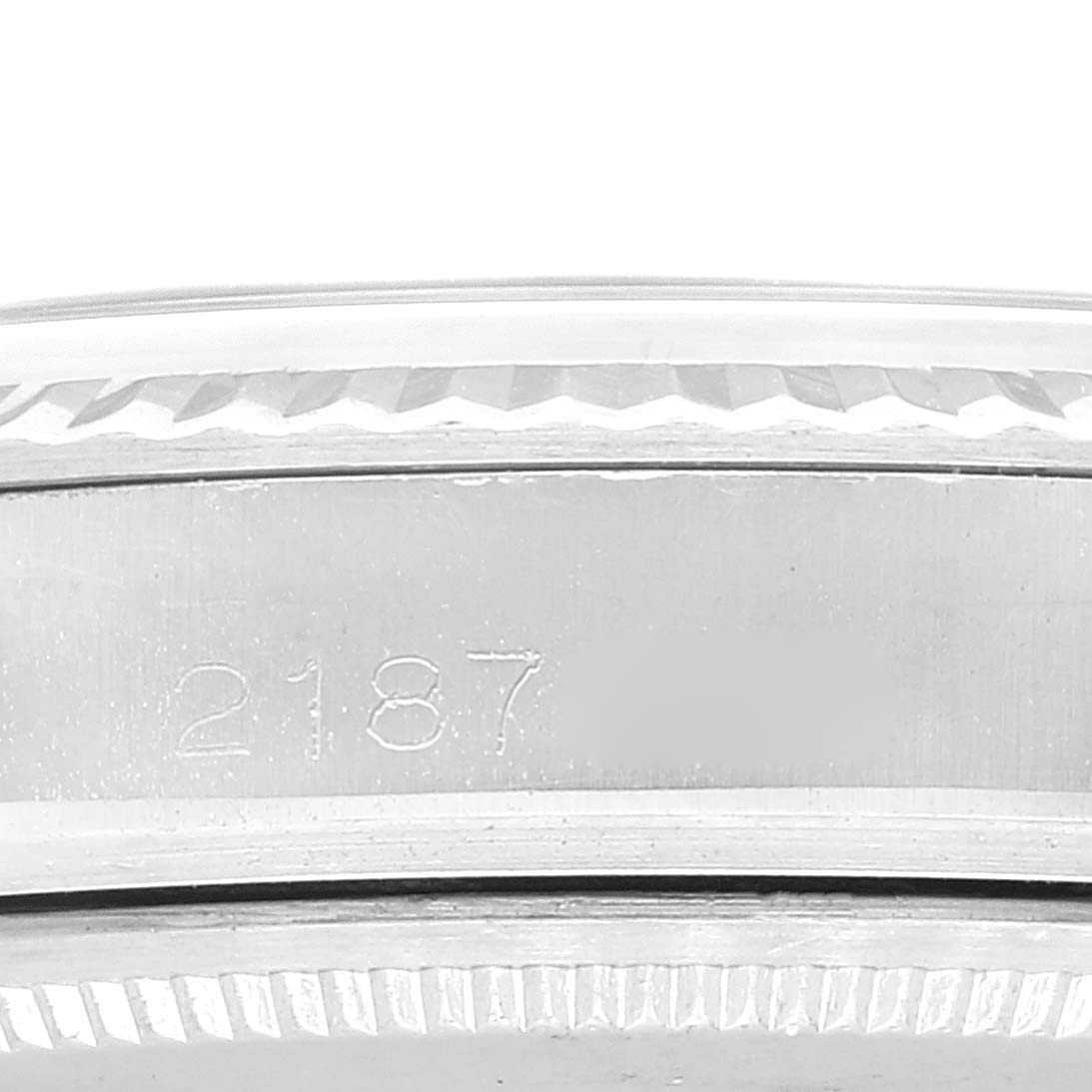This image shows a close-up of the engraved side bezel of a Rolex Vintage Collection 1601 Men's Stainless Steel Silver Dial 1601 Men's Stainless Steel Silver Dial watch, adorned with the number "2187."