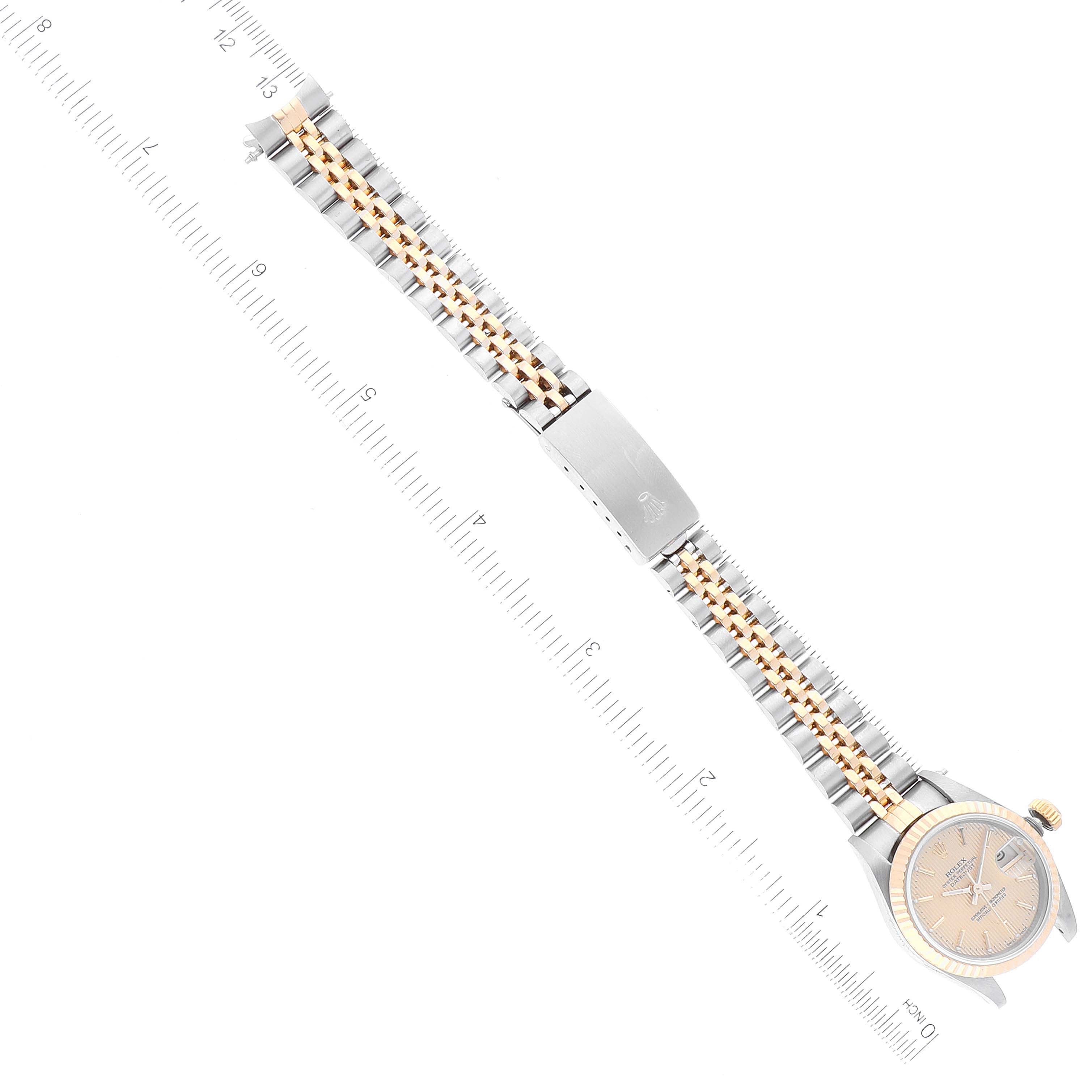The image shows a Rolex Datejust 69173 Women's Steel and Gold (two tone) Champagne Dial 69173 Women's Steel and Gold (two tone) Champagne Dial watch laid flat, highlighting its face, bezel, and two-tone metal bracelet with a deployment clasp.