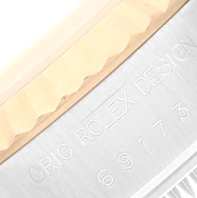 This close-up image of a Rolex Datejust 69173 Women's Steel and Gold (two tone) Champagne Dial 69173 Women's Steel and Gold (two tone) Champagne Dial watch shows part of the bezel and engraved text on the case.