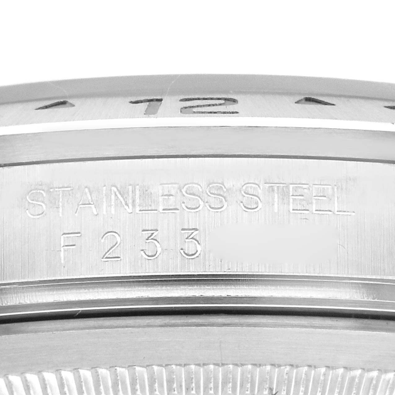 The image shows an angled close-up of the side of a Rolex Explorer 16570 Men
s Stainless Steel Black Dial 16570 Men
s Stainless Steel Black Dial watch, focusing on the serial number and "STAINLESS STEEL" engraving.