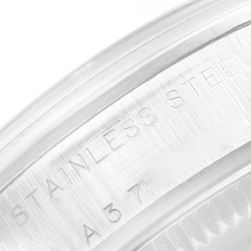 The image shows a macro shot of the side casing of a Mid-Size Rolex watch, highlighting the "STAINLESS STEEL" engraving.