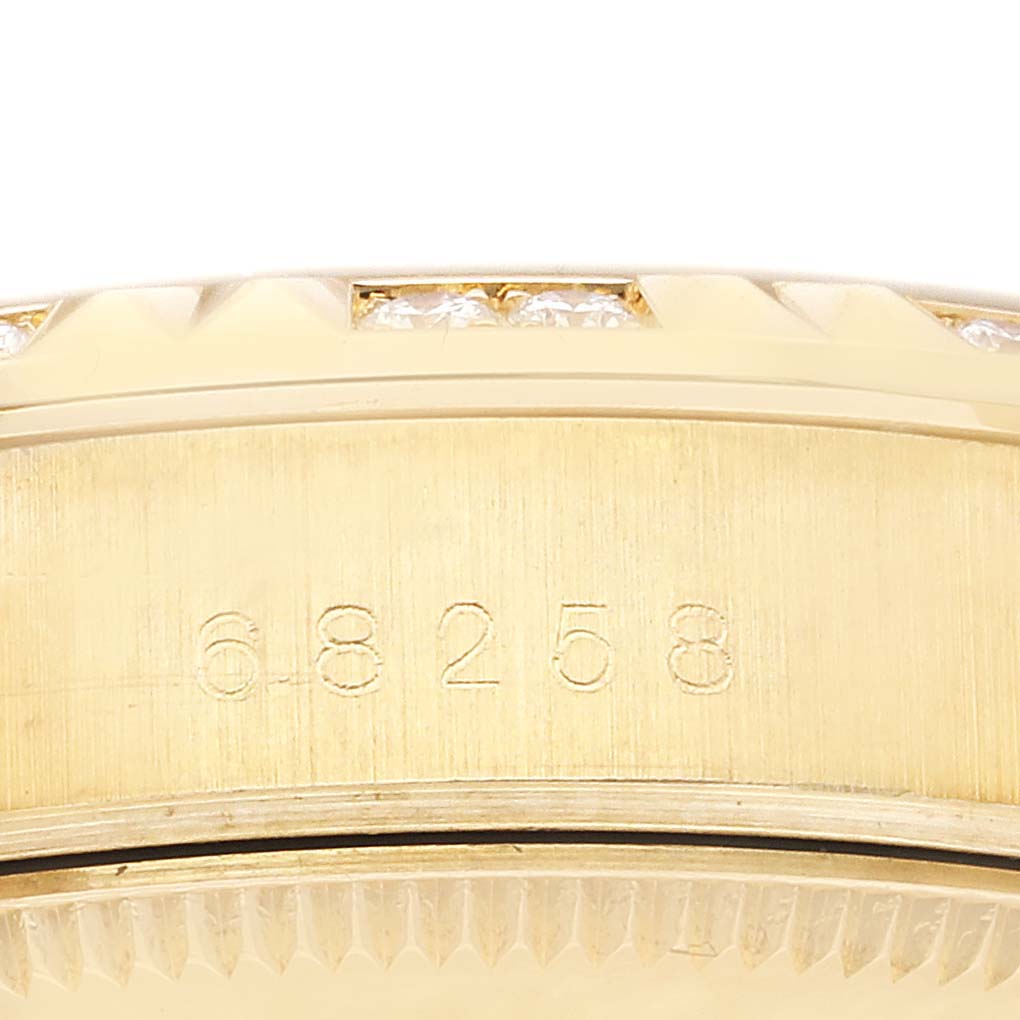 This image shows a close-up of the serial number engraved on the side of a Rolex President 68258 Women's Yellow Gold Silver Dial 68258 Women's Yellow Gold Silver Dial model watch, just below the diamond-studded bezel.