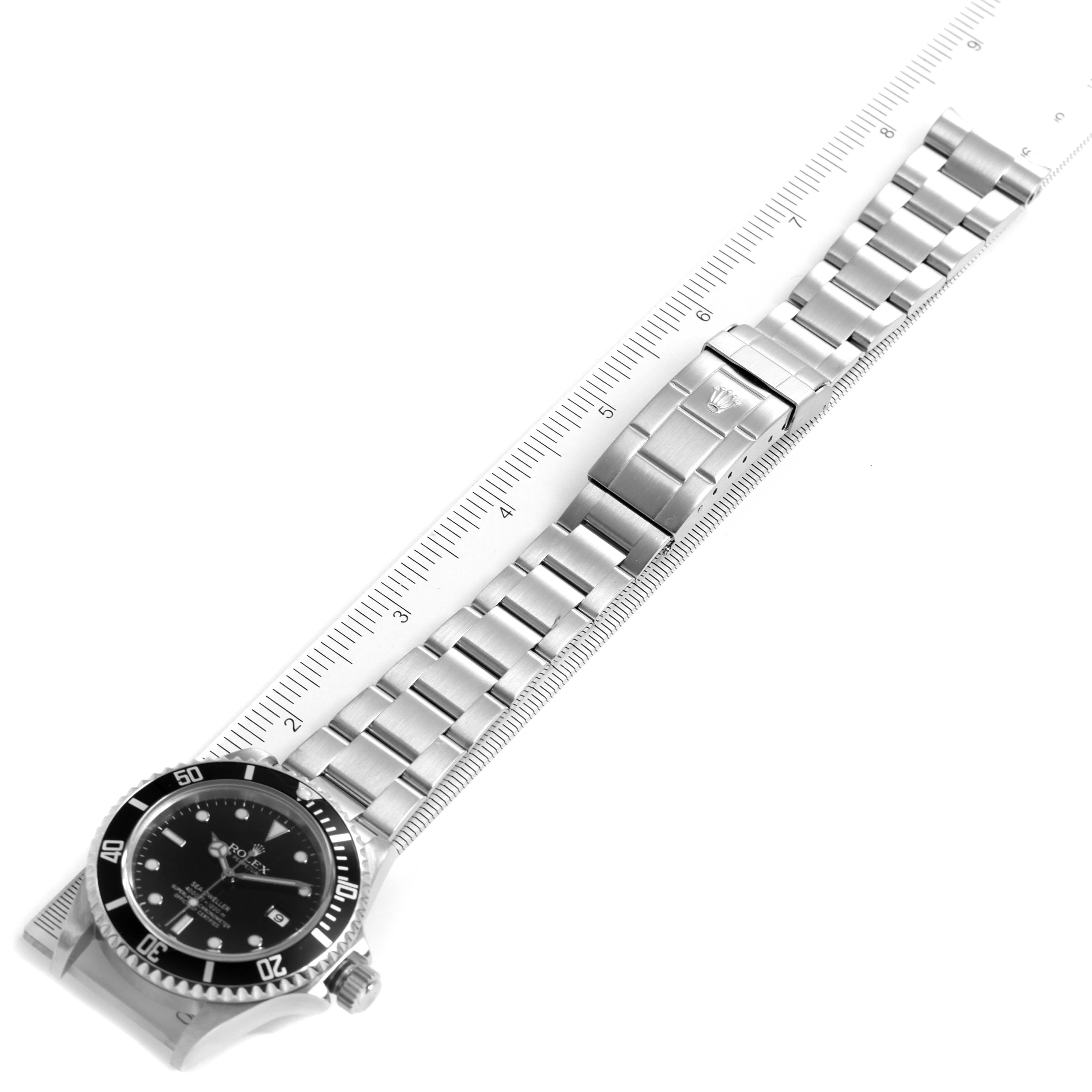 The image shows a top-down view of a Rolex Sea-Dweller 16600 Men
s Stainless Steel Black Dial 16600 Men
s Stainless Steel Black Dial watch with its full metal bracelet and a ruler for scale.