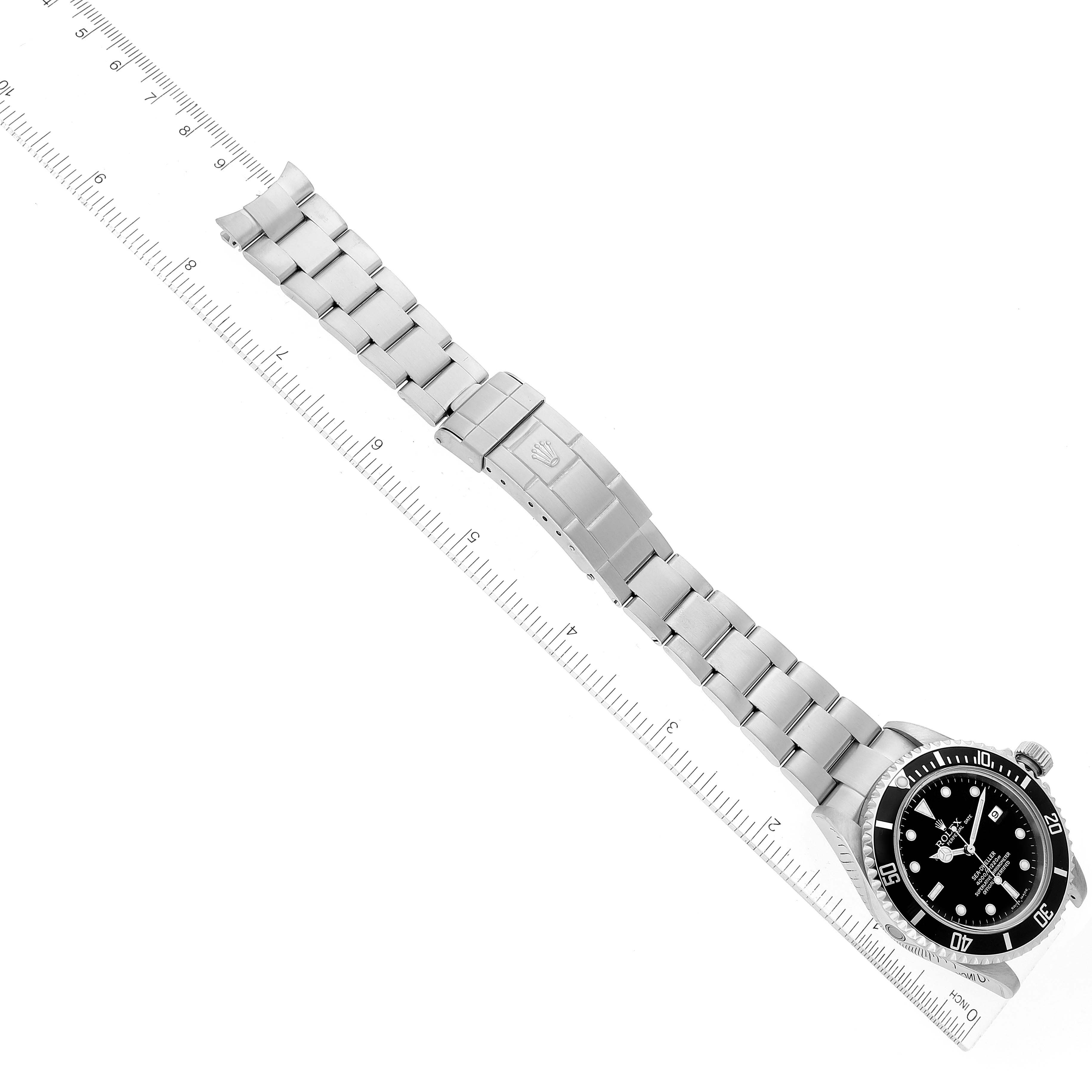 The image shows a top-down view of a Rolex Sea-Dweller 16600 Men
s Stainless Steel Black Dial 16600 Men
s Stainless Steel Black Dial watch, featuring its face, bezel, and full bracelet near a ruler for scale.