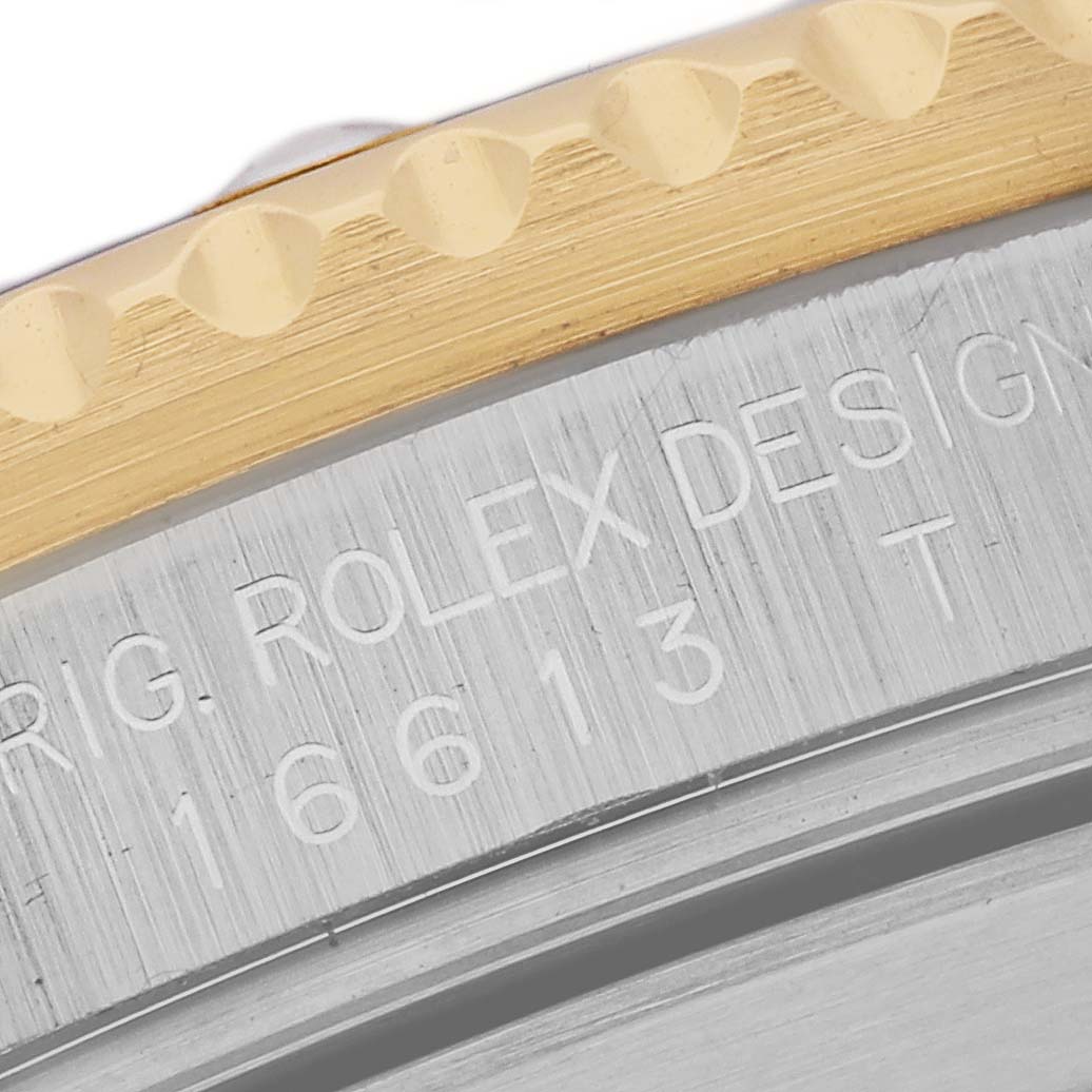 The image shows a close-up of the engraved side of the case and bezel of a Rolex Submariner 16613 Men's Steel and Gold (two tone) Blue Dial 16613 Men's Steel and Gold (two tone) Blue Dial model.