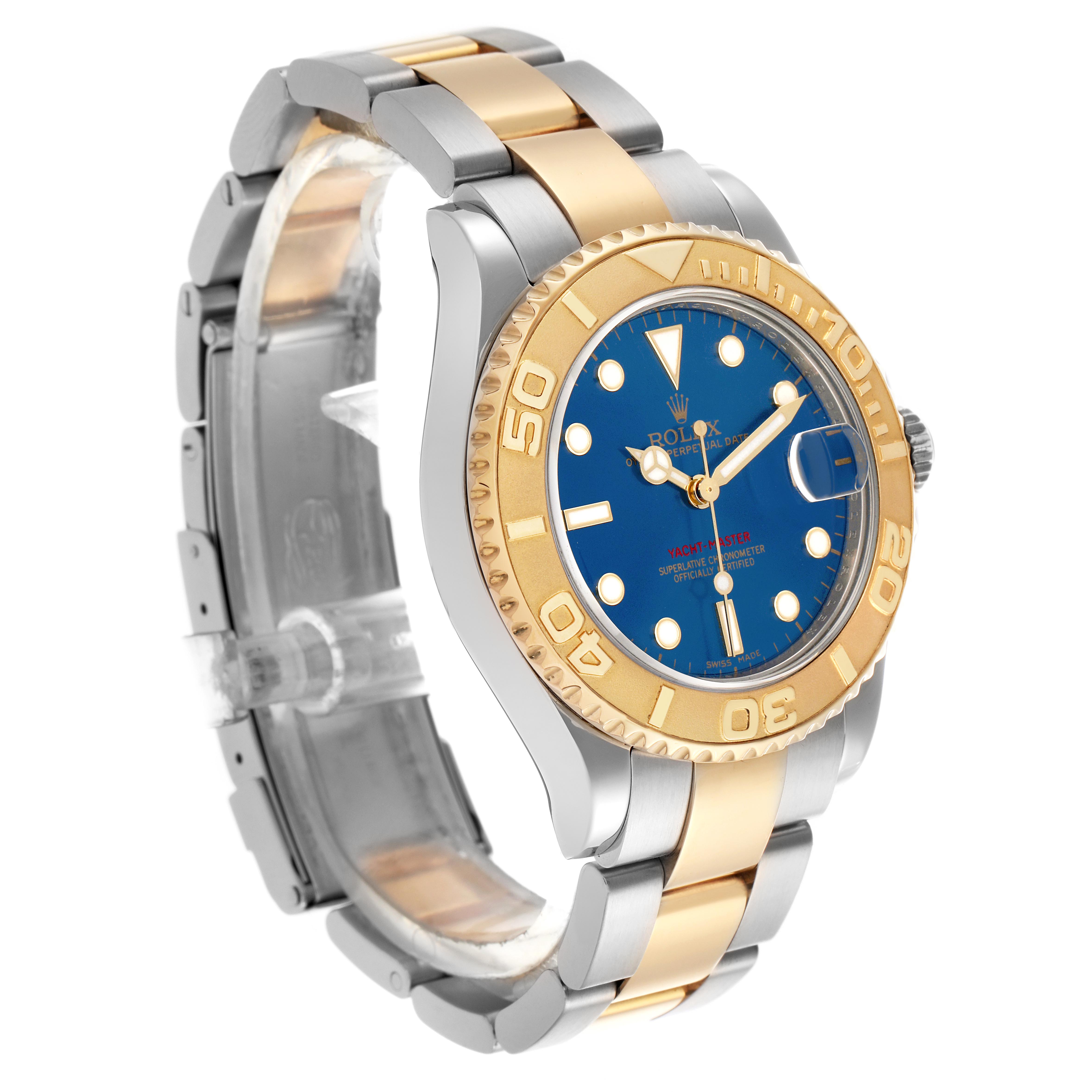 The Rolex Yacht-Master 168623 Men
s Steel and Gold (two tone) Blue Dial 168623 Men
s Steel and Gold (two tone) Blue Dial watch is shown at a three-quarter angle, highlighting its blue dial, gold bezel, and two-tone bracelet.